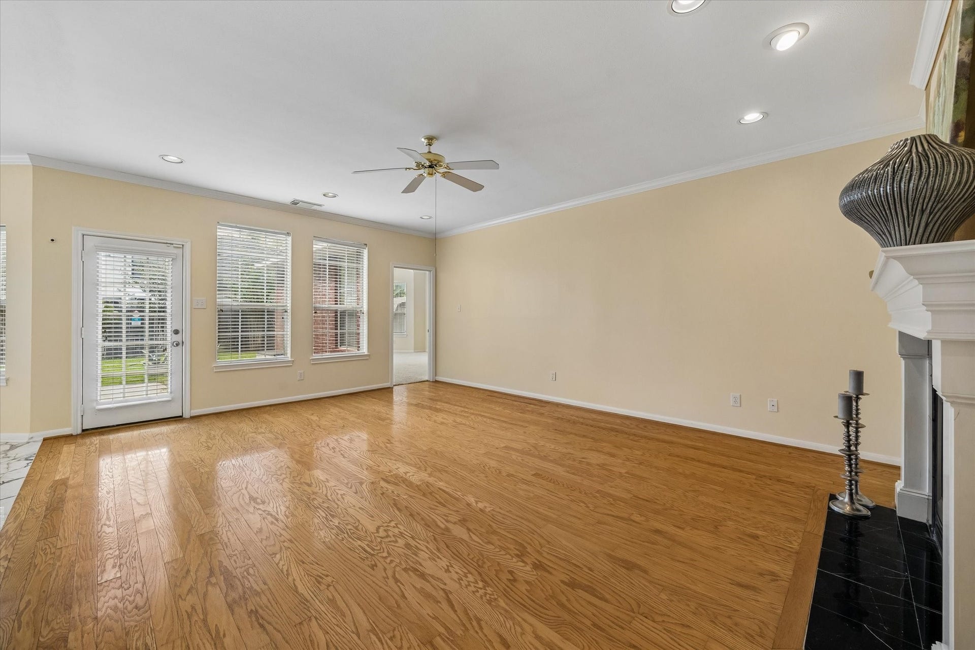 1115 Mulberry Lane, Bellaire, TX 77401 Spacious living area with beautiful hardwood floors, abundant natural light from large windows, and a cozy fireplace, perfect for family gatherings.