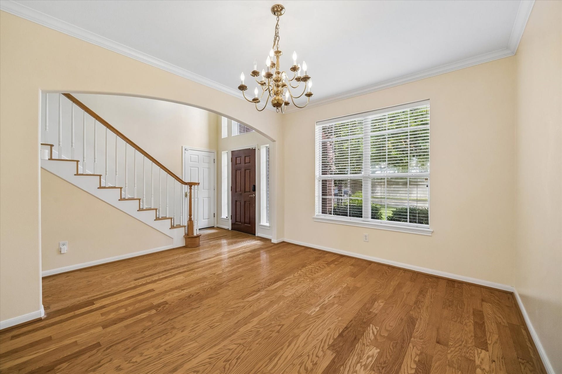 1115 Mulberry Lane, Bellaire, TX 77401 Elegant entryway featuring rich hardwood floors, a charming staircase, and a stunning chandelier.