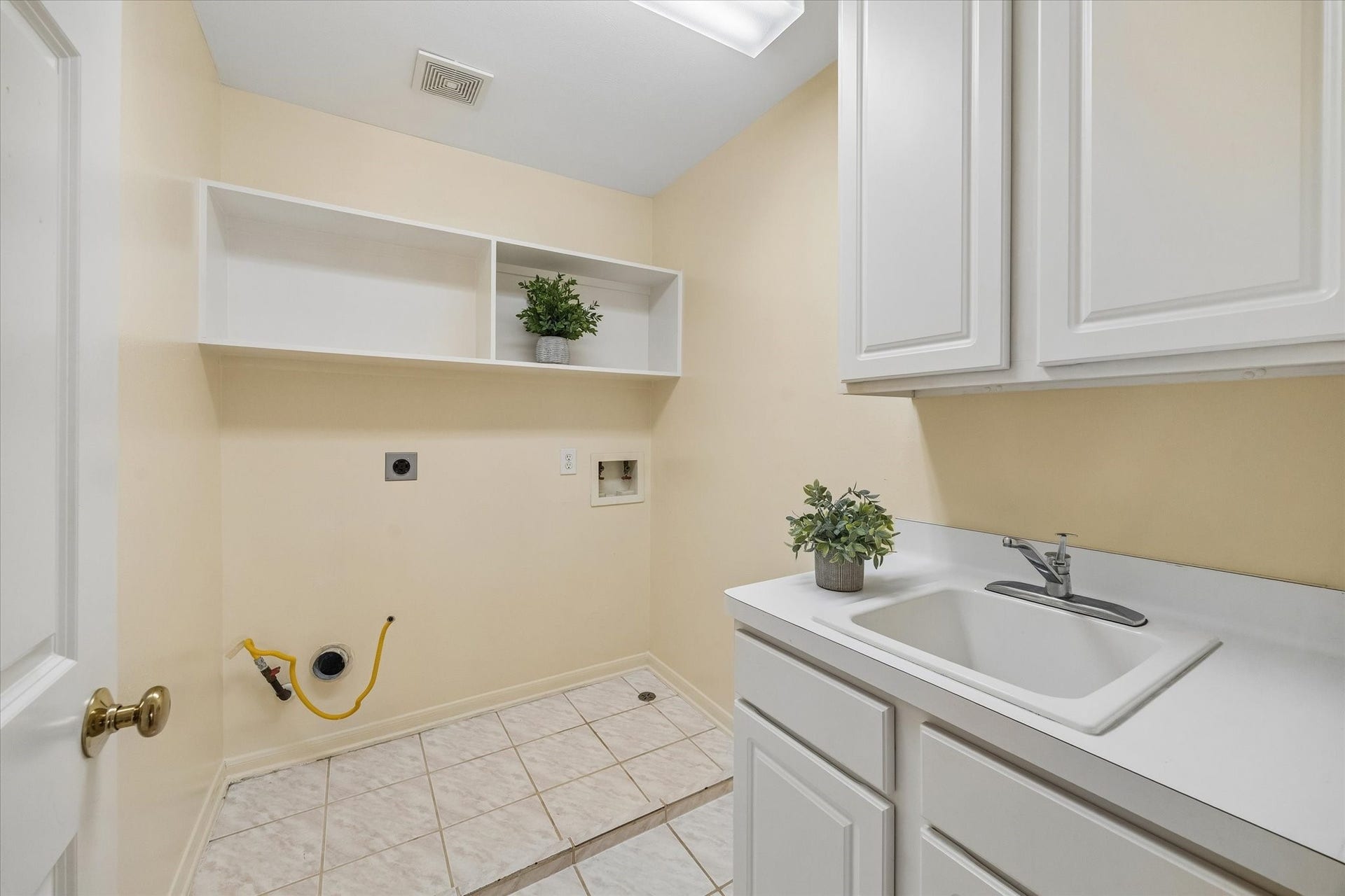 1115 Mulberry Lane, Bellaire, TX 77401 The laundry room with tile flooring, built-in shelving, and a deep utility sink, offering ample storage and functionality is located on the 2nd floor.