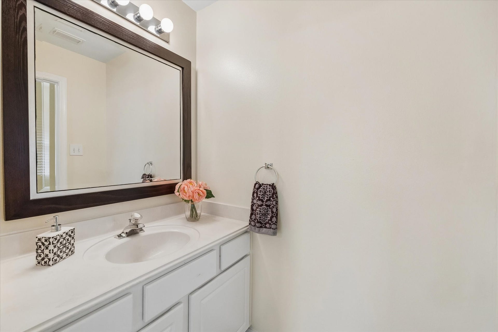 1115 Mulberry Lane, Bellaire, TX 77401 Stylish bathroom with a sleek countertop, elegant framed mirror, and soft lighting, offering a welcoming atmosphere.