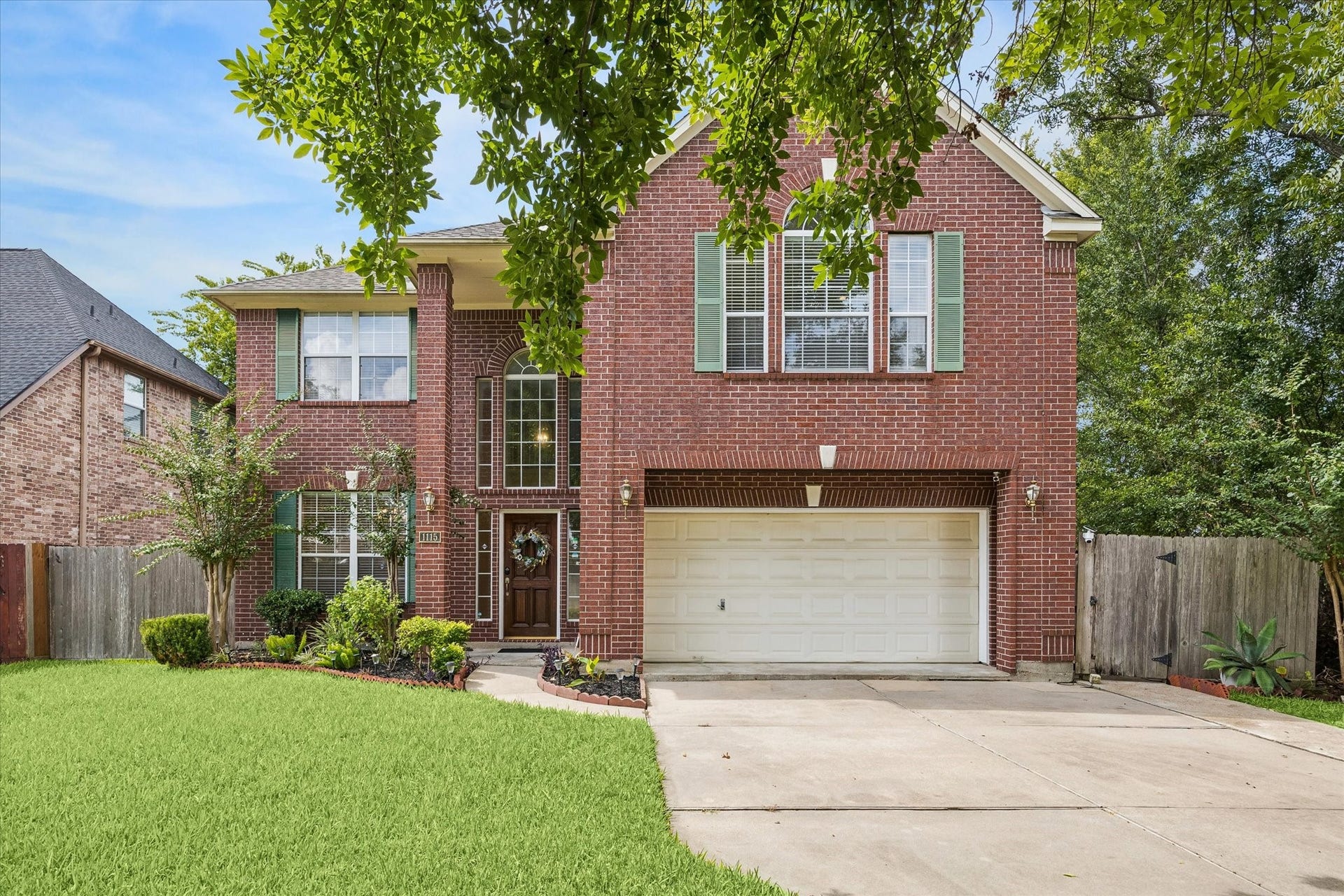 1115 Mulberry Lane, Bellaire, TX 77401 Stunning two-story brick home with lush landscaping, large windows, and a spacious two-car garage.