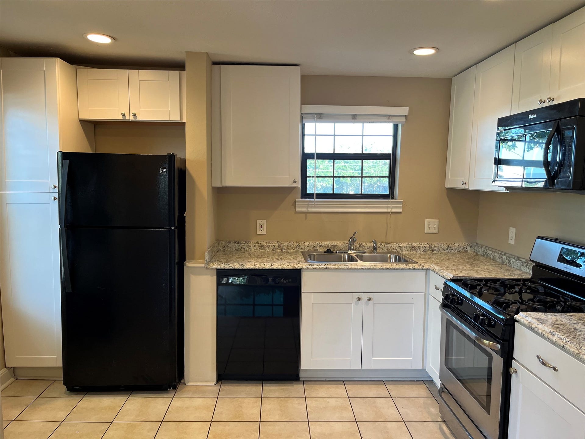 Kitchen with granite countertops, gas cooking, and a window view to downtown.  Property comes with all appliances (refrigerator, microwave, washer, and dryer.