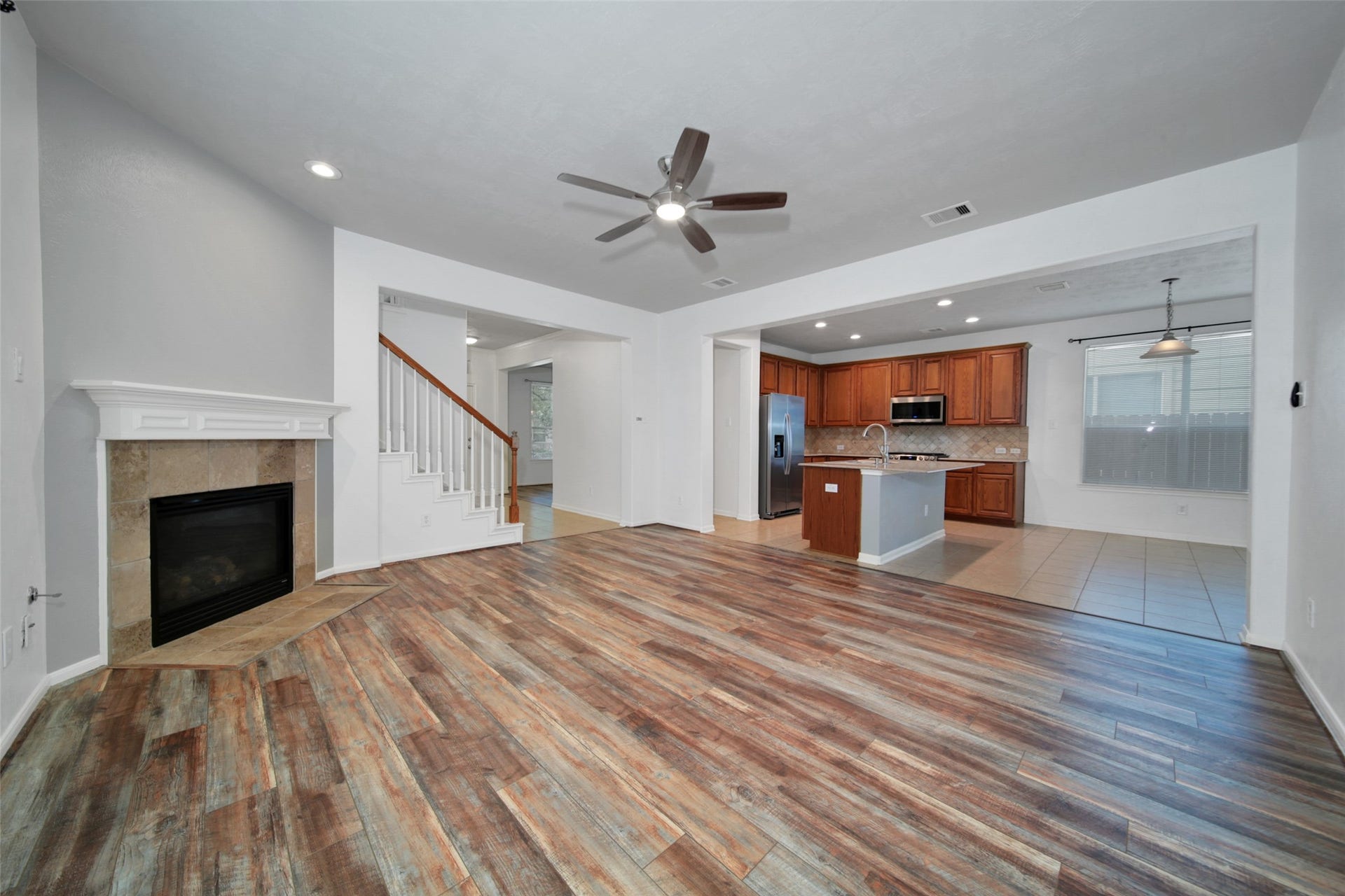 Open concept floorplan with wood laminate flooring in the living room.