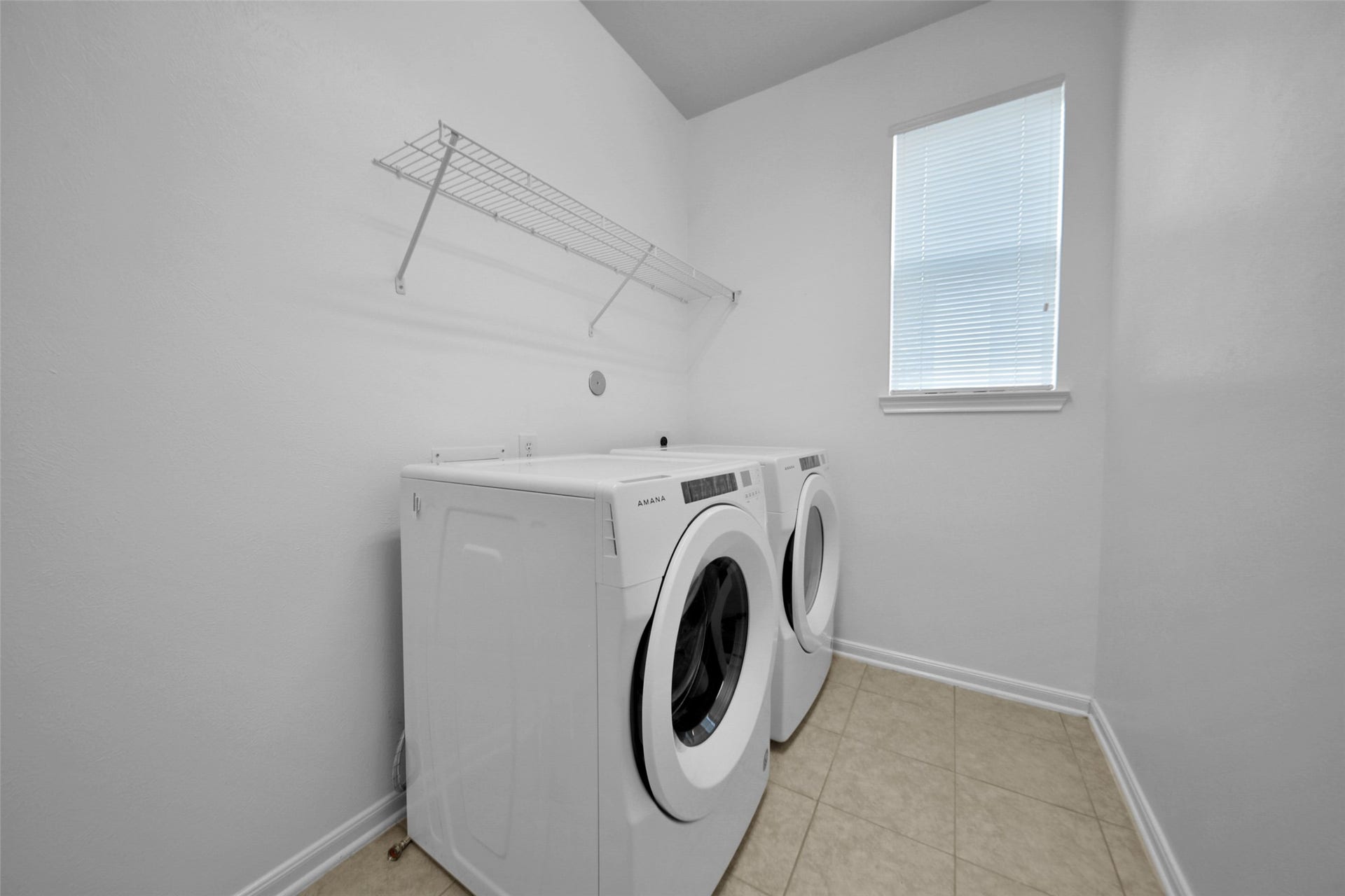 Utility room with front load washer and dryer included.