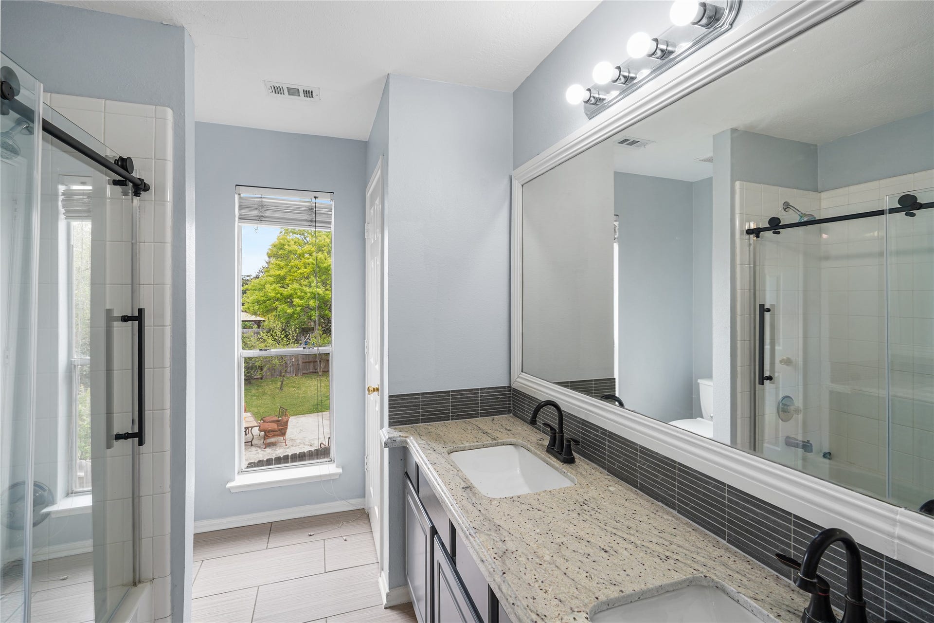 2623 Pine Shadows Drive, Sugar Land, TX 77479 Beautifully renovated secondary bathroom with dual vanities and sleek, brand new glass shower doors