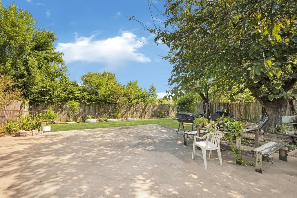 Expansive backyard oasis with ample patio space, mature trees, perfect for outdoor gatherings and relaxation.
