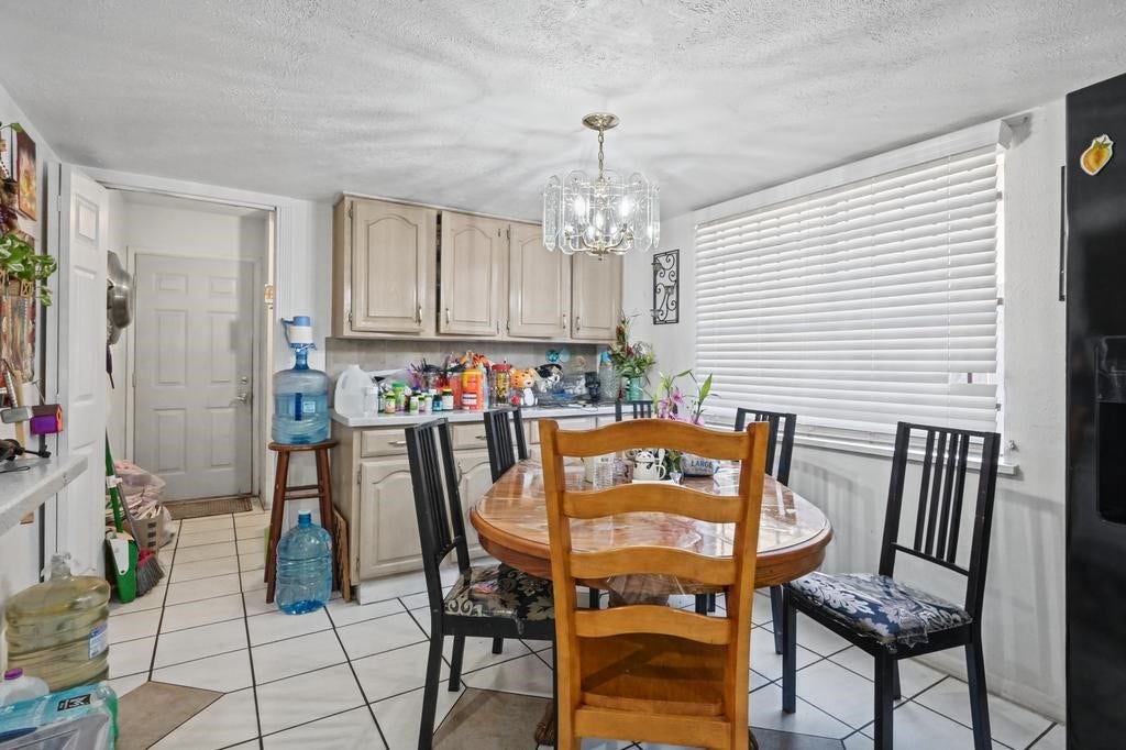 Bright dining area with chandelier, abundant natural light from a large window.
