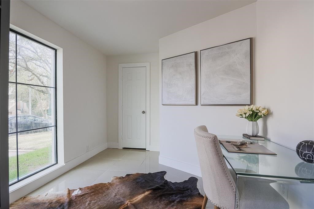 5614 Indian Circle, Houston, TX 77056 Private home office with large windows offering serene views of the meticulously manicured front yard. This refined workspace combines comfort and sophistication, featuring abundant natural light for a productive yet tranquil environment.