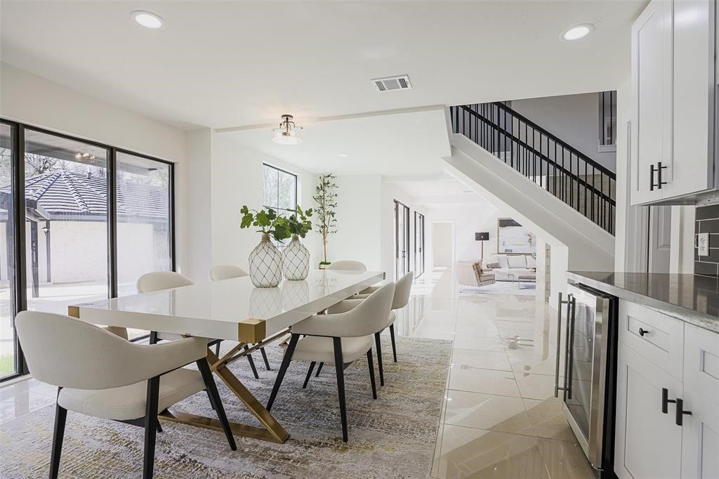5614 Indian Circle, Houston, TX 77056 Spacious dining area with sleek tile flooring and a crisp white color palette, offering a bright and airy atmosphere. Large windows provide picturesque views of the pool, blending indoor dining with a serene outdoor backdrop.