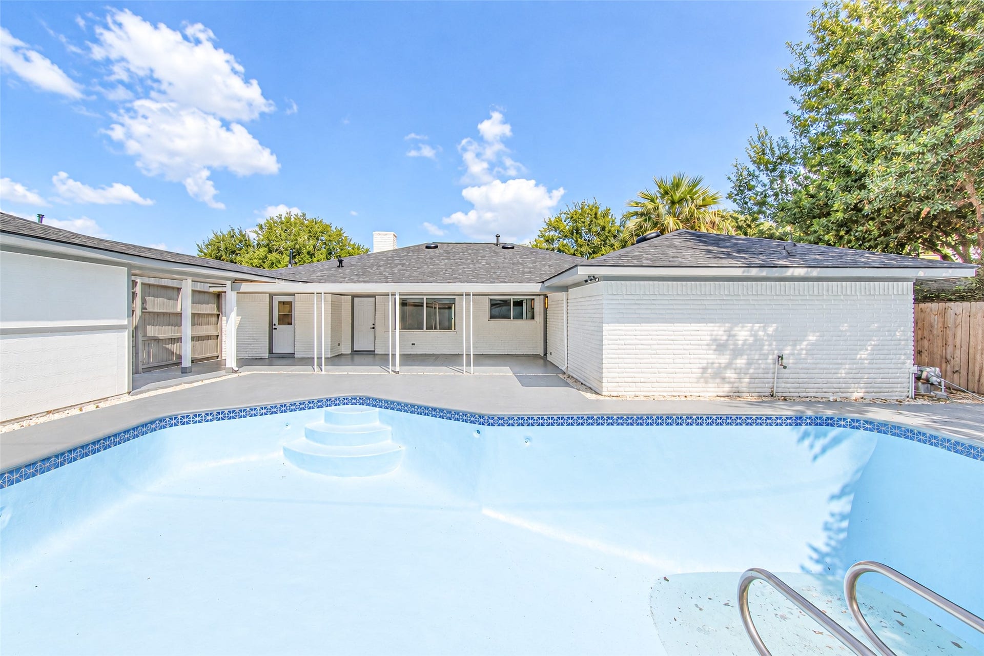 7623 Braes Meadow Drive, Houston, TX 77071 Spacious backyard featuring a pristine pool and ample patio space, perfect for outdoor relaxation and entertainment.
