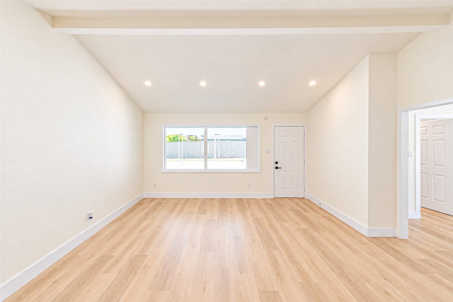 7623 Braes Meadow Drive, Houston, TX 77071 Discover a spacious living area with vaulted ceilings, sleek recessed lighting, and abundant natural light streaming through a large window, all beautifully complemented by luxury vinyl flooring.