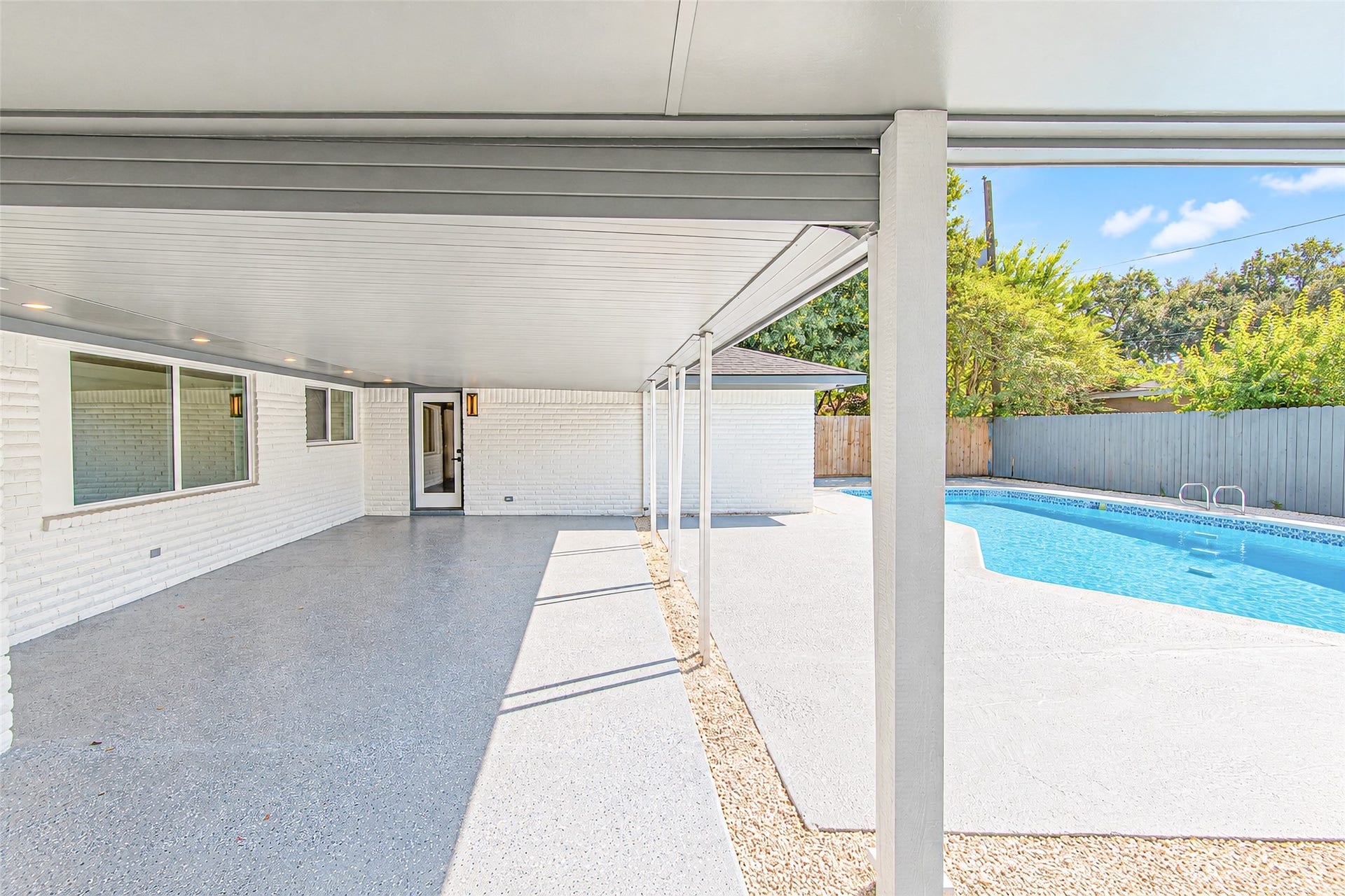 7623 Braes Meadow Drive, Houston, TX 77071 Enjoy serene outdoor living with a spacious covered patio overlooking a sparkling pool, perfect for relaxation and entertaining.
