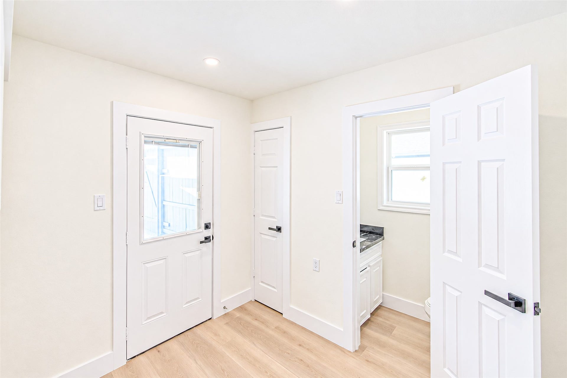 7623 Braes Meadow Drive, Houston, TX 77071 Bright and inviting space with luxury vinyl flooring, featuring a convenient side entry and a compact utility area illuminated by a small window.