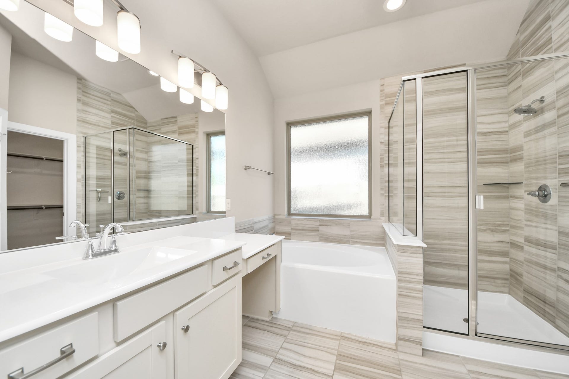 6110 Dovetail Cliff Court, Katy, TX 77493 Luxurious primary bathroom featuring dual vanities, a soaking tub, and a separate glass enclosed shower.