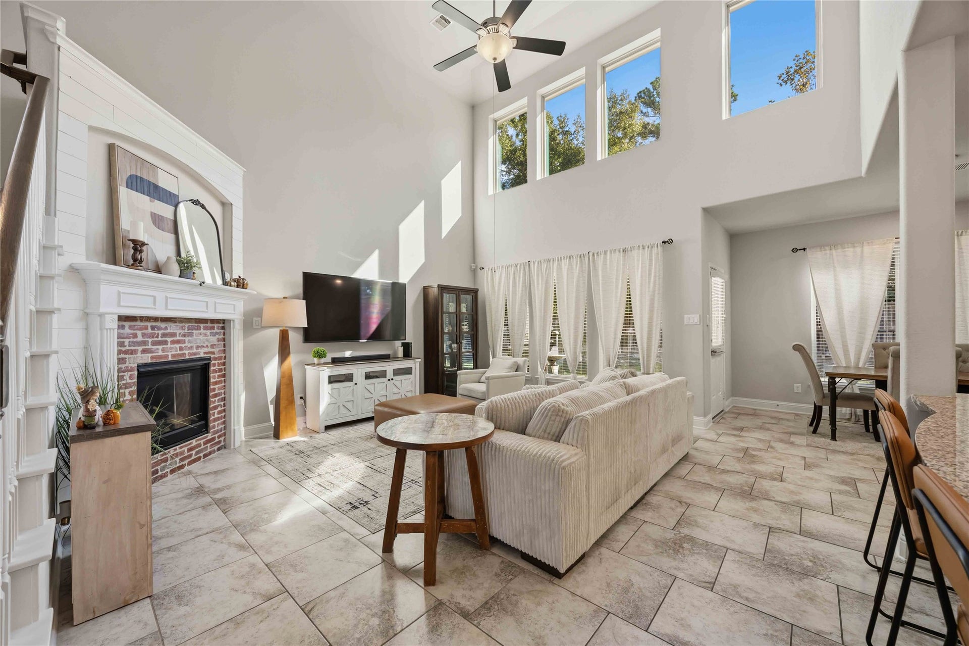 3152 Copeland Bend, Conroe, TX 77301 Walls of windows pour light into the two-story living room, anchored by a cozy fireplace.