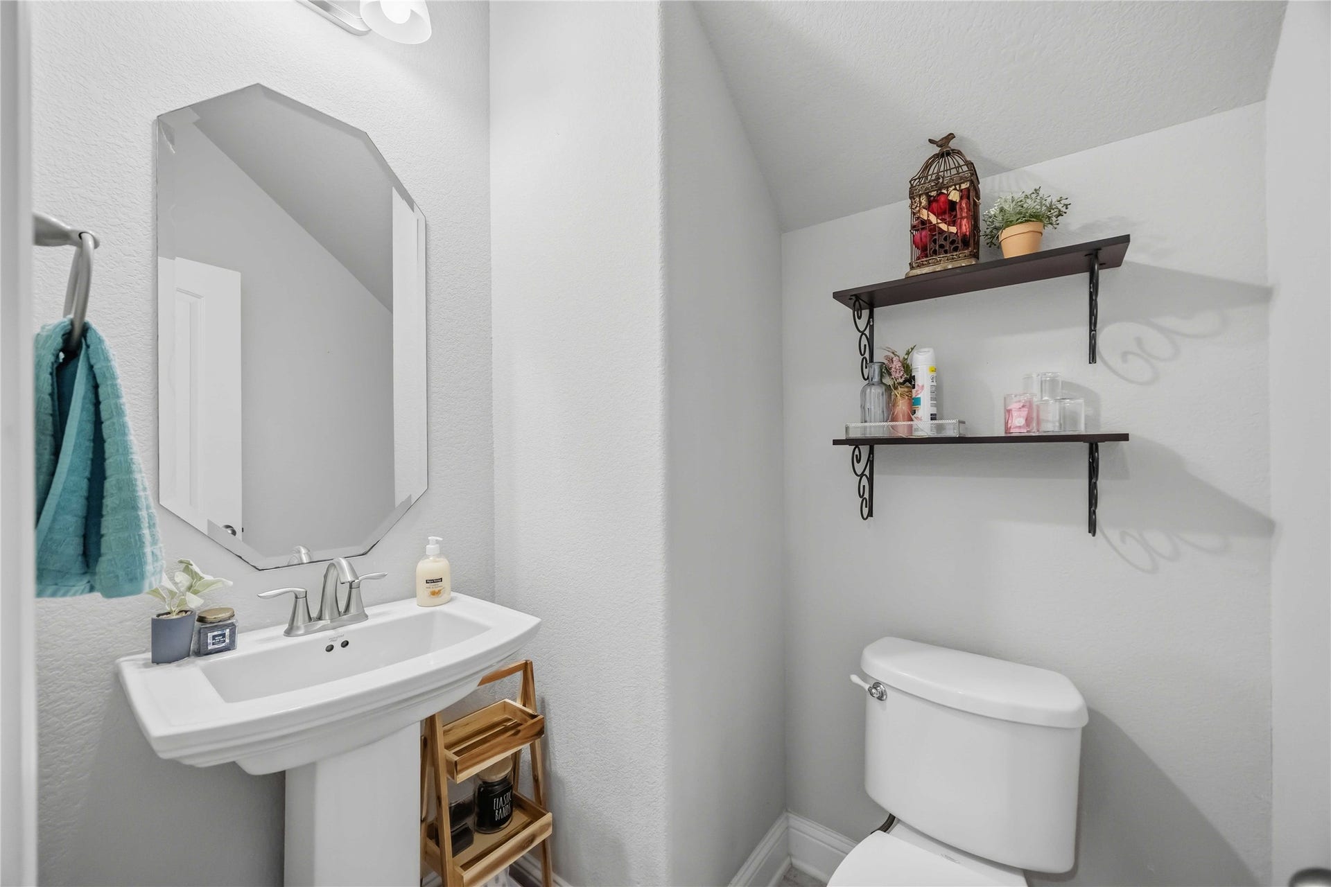 3152 Copeland Bend, Conroe, TX 77301 The powder bath is a charming spot for guests, with a pedestal sink and floating shelves.