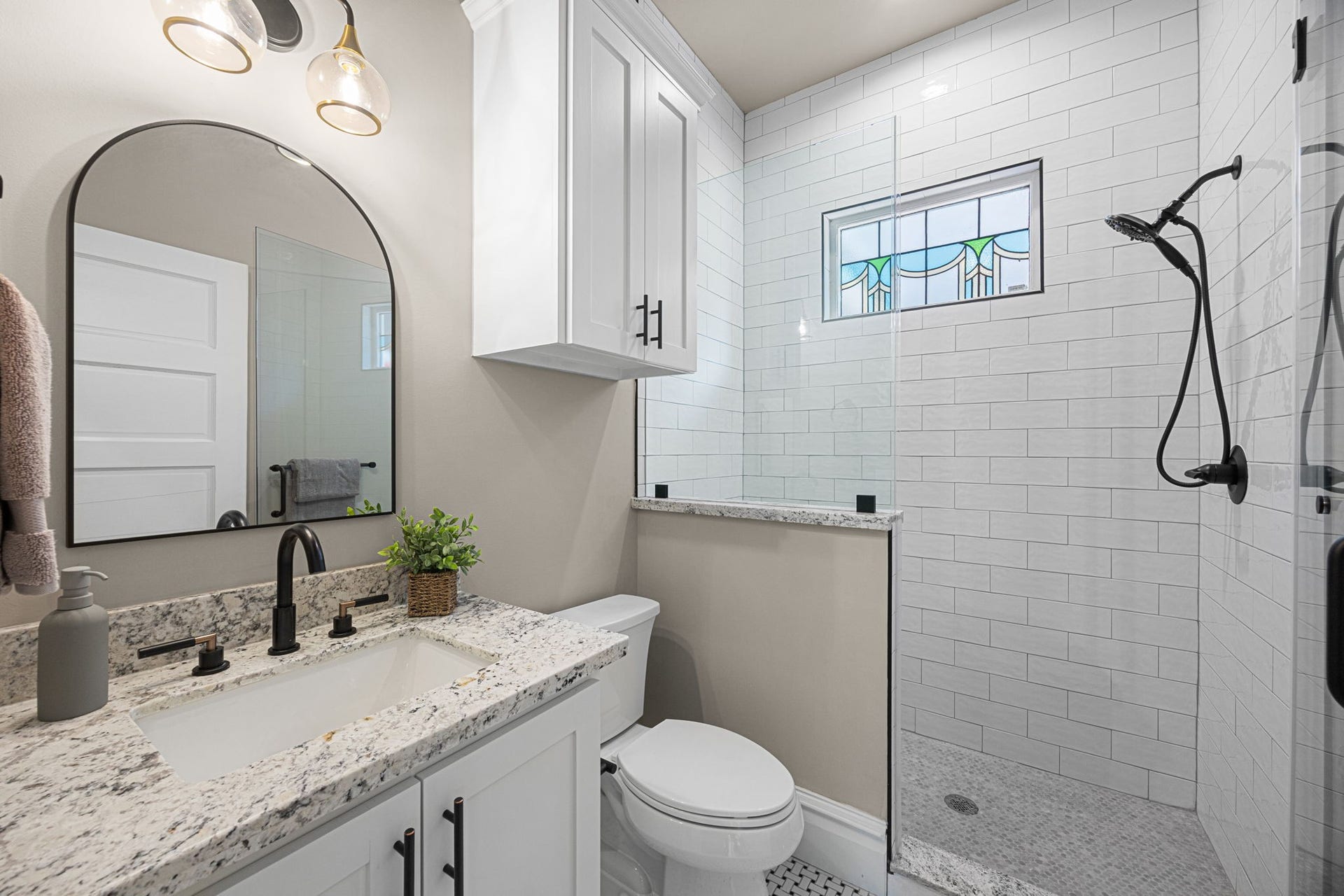 1521 Ovid Street, Houston, TX 77007 En-suite bathroom for the 1st floor bedroom, with a nicely appointed walk-in shower with frameless glass surround, accent window, and timeless subway tile run to the ceiling.