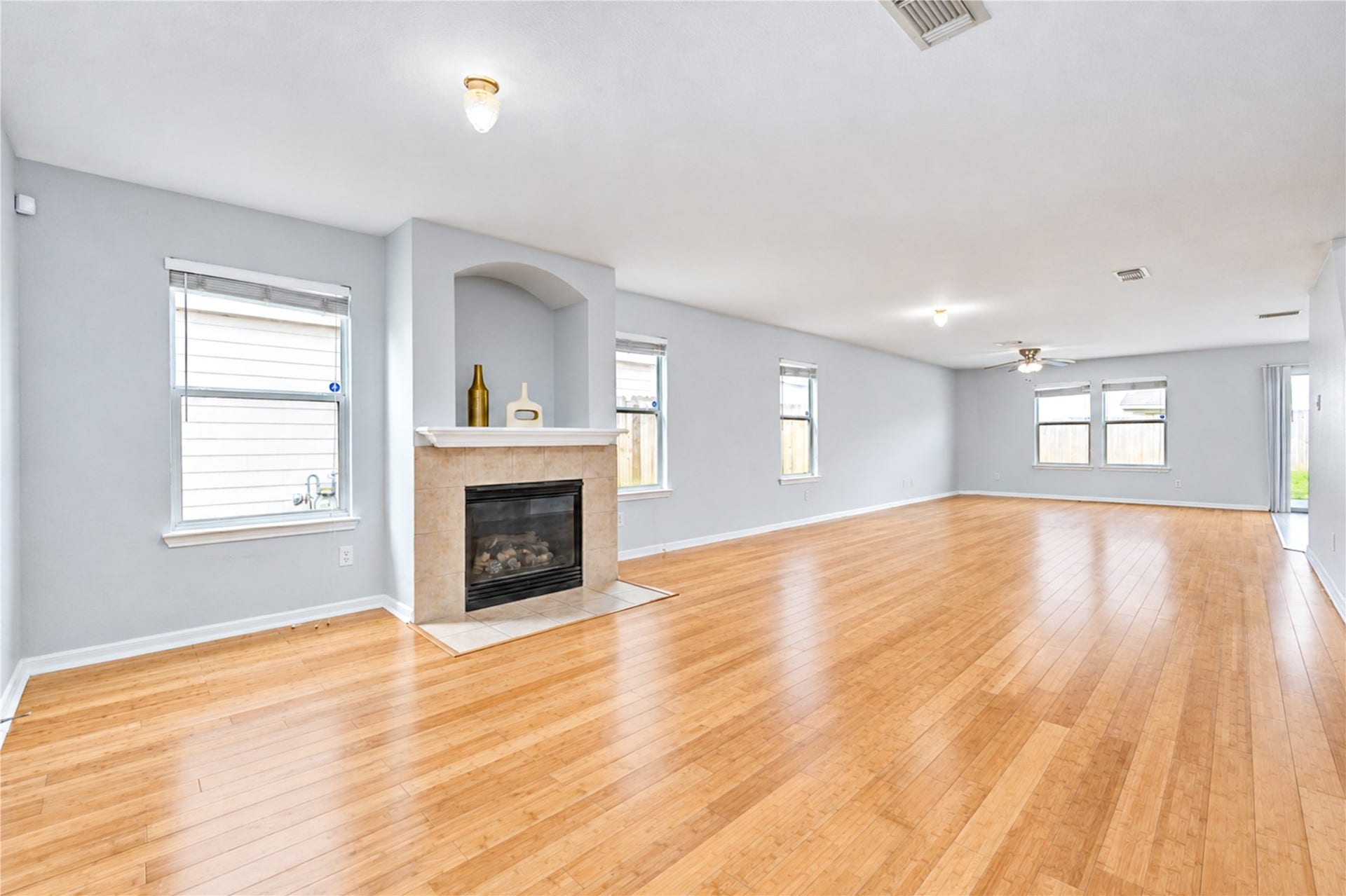 20910 Trenton Valley Lane, Katy, TX 77449 Spacious open concept living area featuring beautiful bamboo wood floors, abundant natural light, and a cozy fireplace.