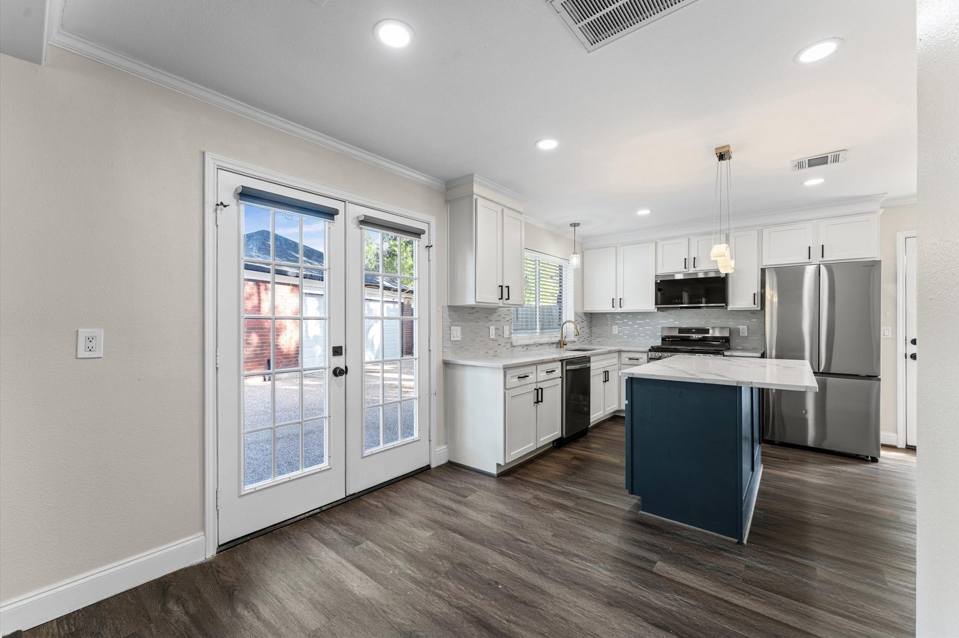 1118 Cheyenne Meadows Drive, Katy, TX 77450 The updated kitchen features white cabinetry, stainless steel appliances, and a center island, with the Breakfast Room alongside.