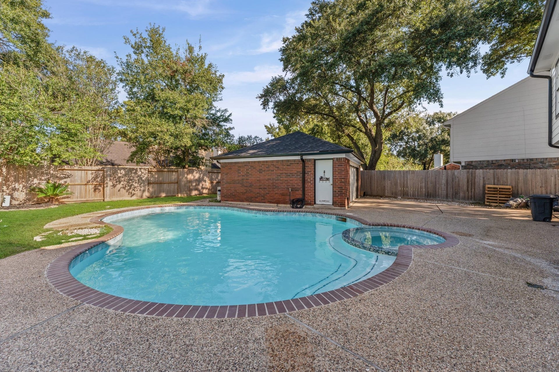 1118 Cheyenne Meadows Drive, Katy, TX 77450 The backyard features an inground swimming pool and spa, with mature trees and space to relax outdoors.
