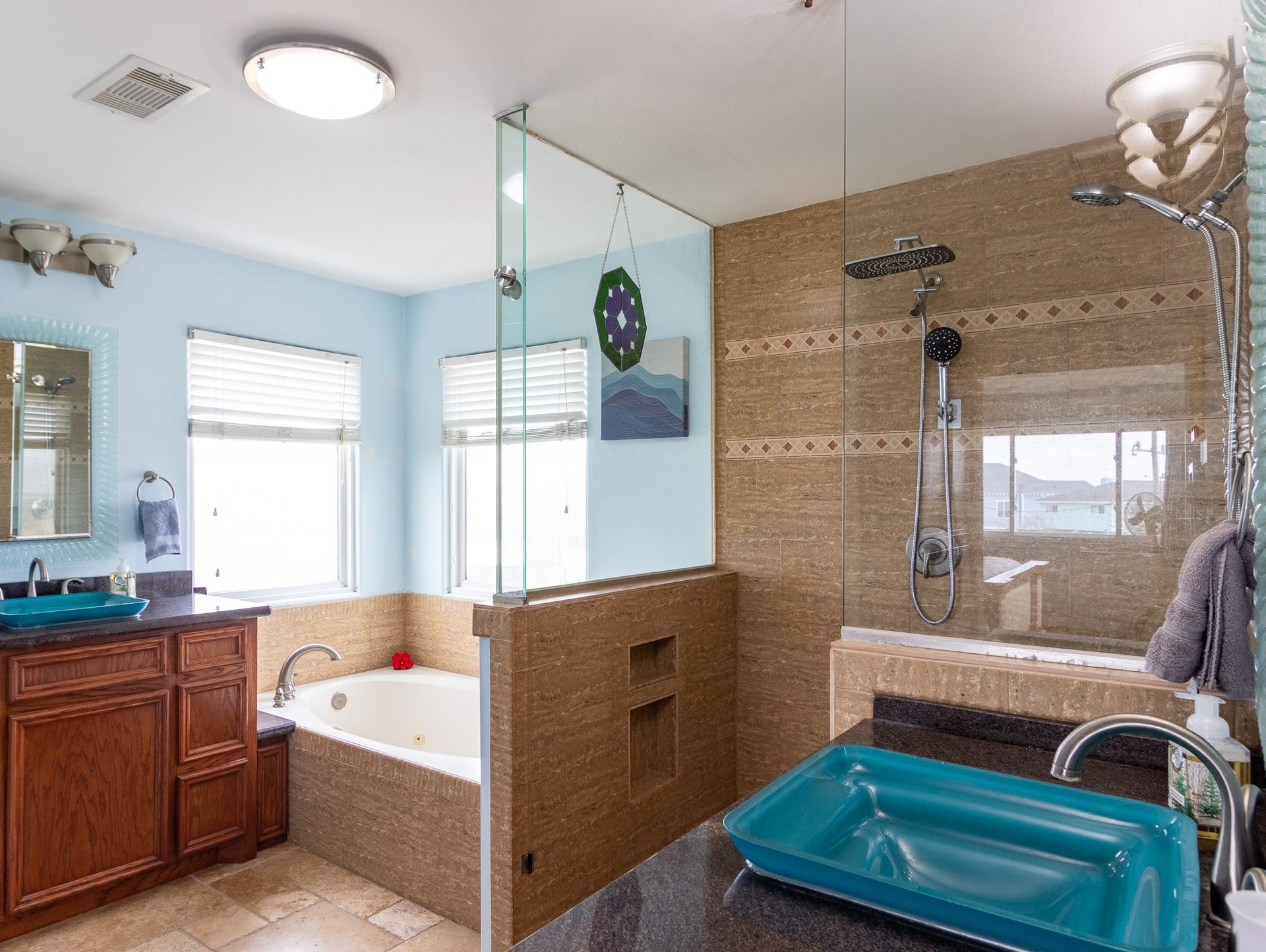 2414 Avenue P, San Leon, TX 77539 Primary ensuite bathroom with dual shower heads. Glass vessel sinks and jetted whirpool spa tub.