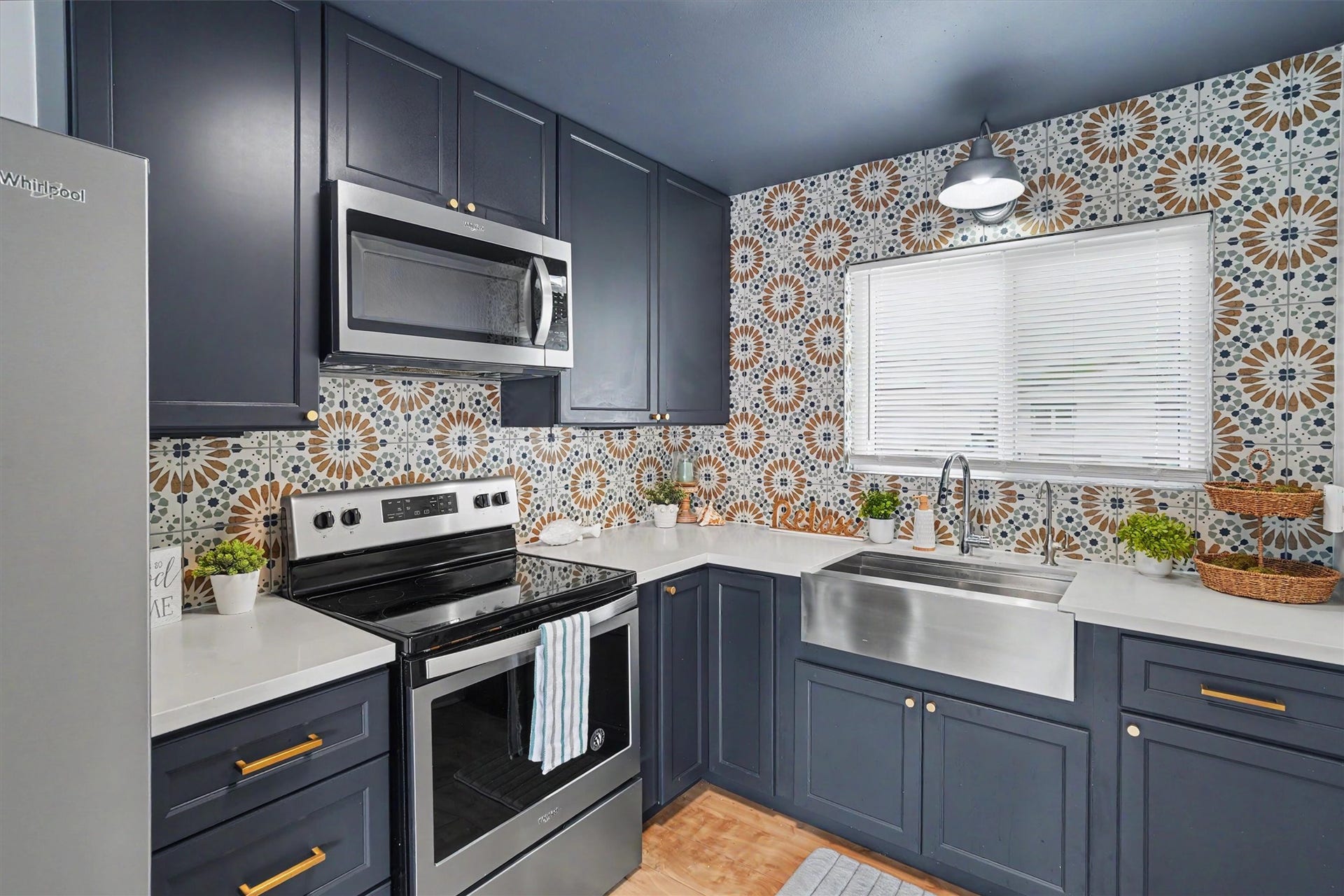 370 Ling Street, Bayou Vista, TX 77563 This modern kitchen is stylish with updated cabinets and brushed gold hardware, stainless appliances and farm sink, a featured kitchen wall with tile to the ceiling, and quartz countertops