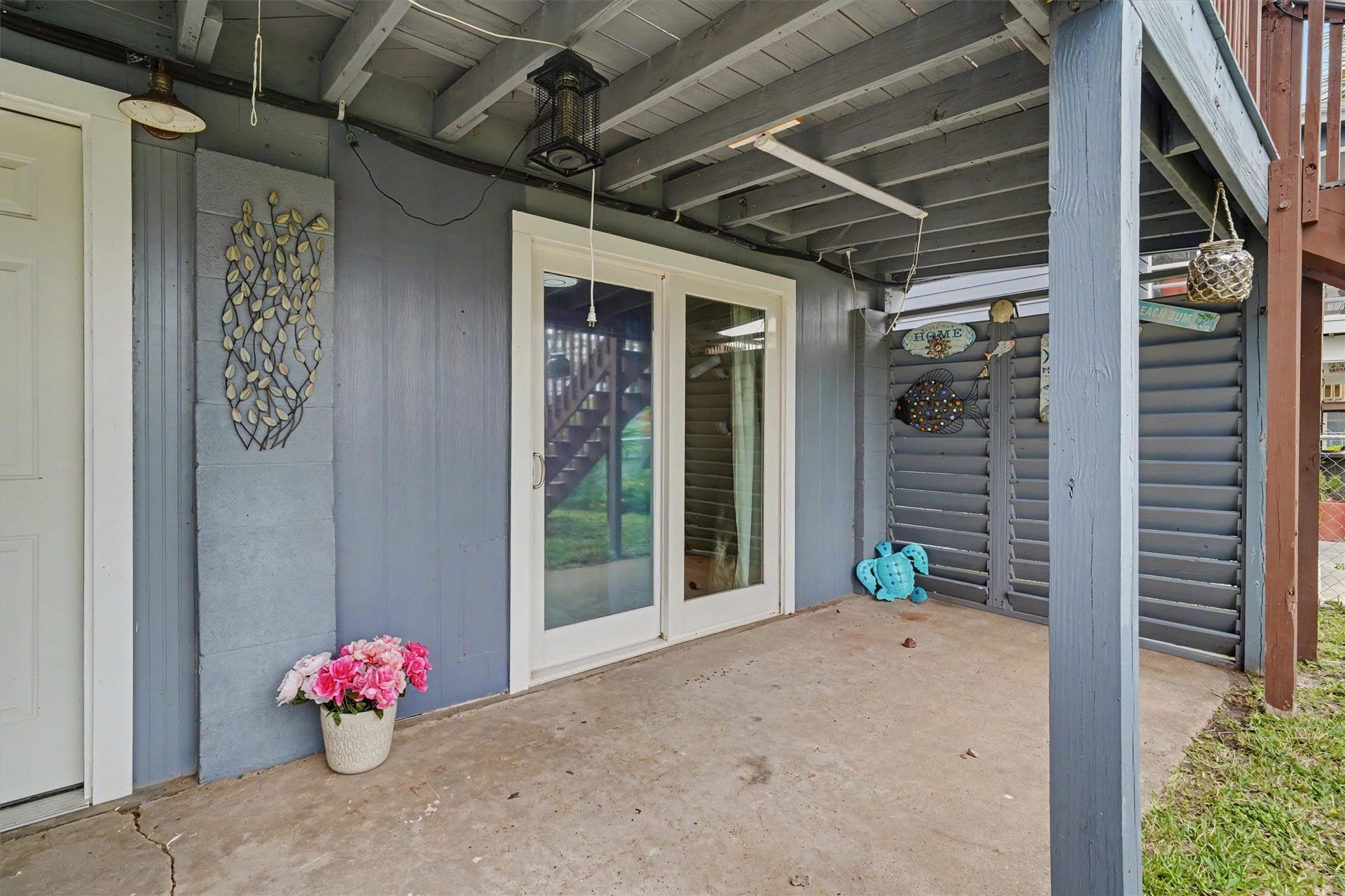 370 Ling Street, Bayou Vista, TX 77563 Downstairs sliding door into a bedroom. Covered entertainment area downstairs for exterior furniture and notice the privacy slats