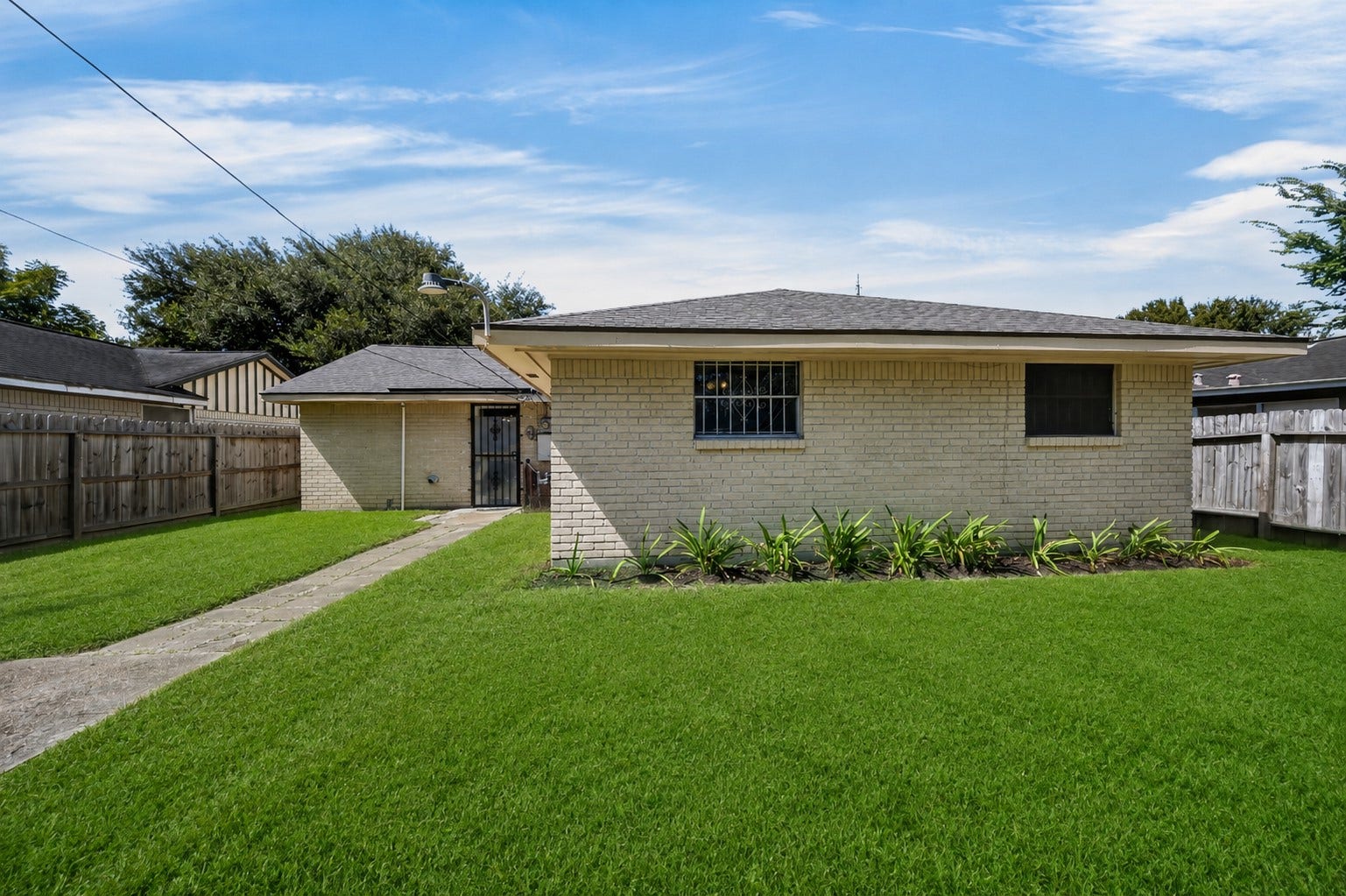 522 Hollyvale Dr, Houston, TX 77060 Well-maintained rear exterior overlooking a spacious green lawn.