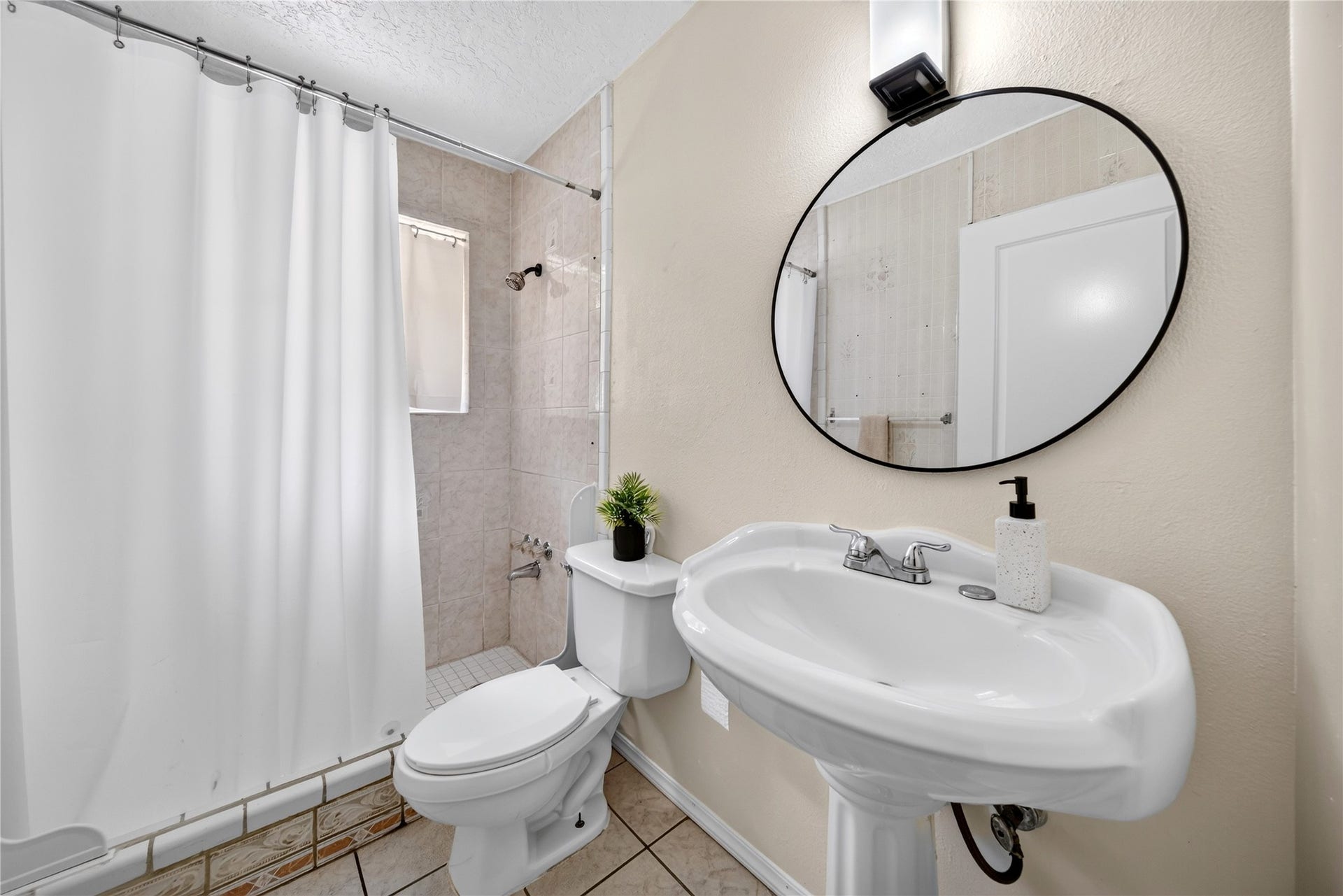 522 Hollyvale Dr, Houston, TX 77060 Bright secondary bath with a charming vanity and classic details.