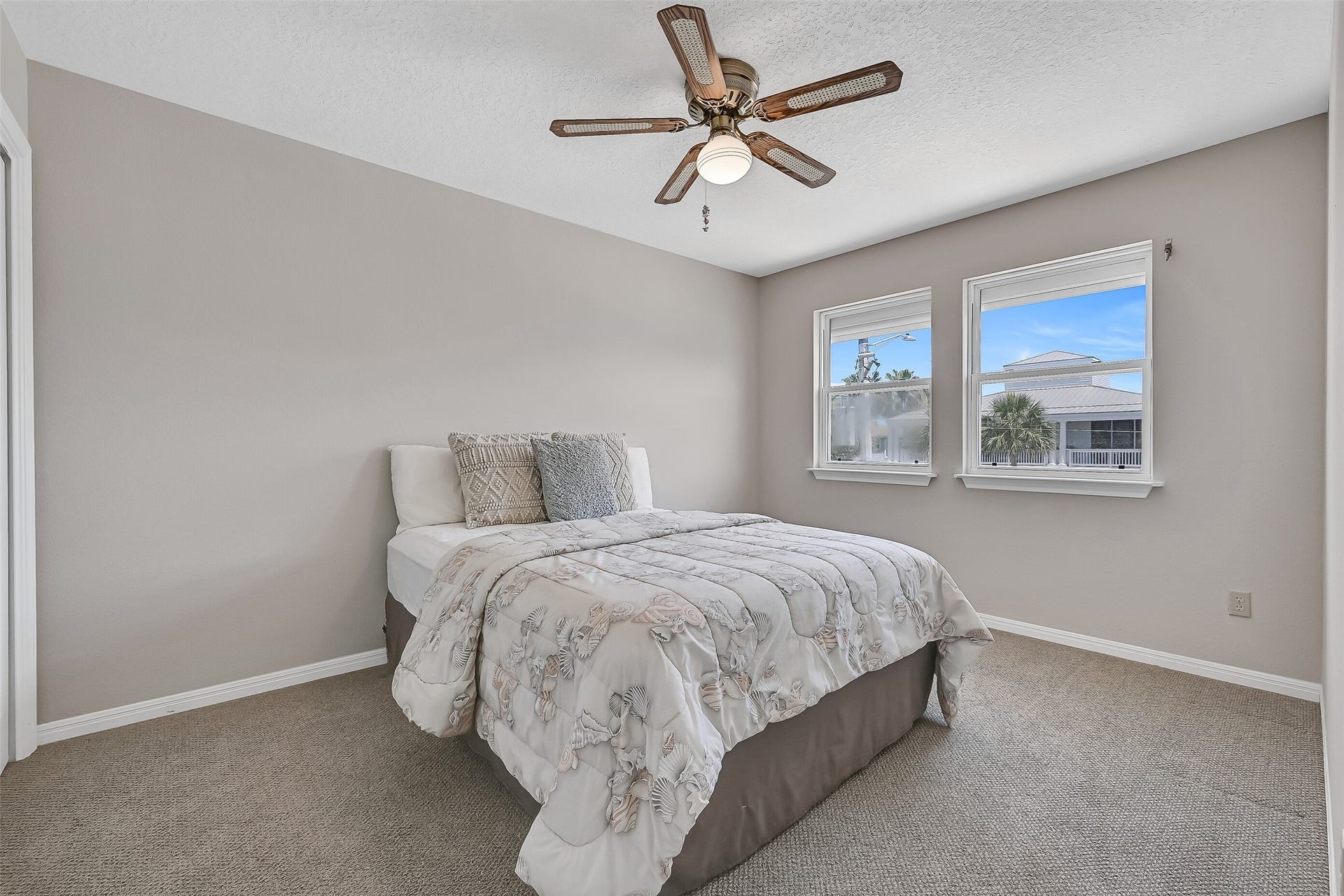 243 Isles End Road, #RR2, Tiki Island, TX 77554 Located on the main living level, this comfortable secondary bedroom offers fresh Sherwin-Williams Natural Linen paint, Berber carpet, a ceiling fan, and easy access to the adjacent full bath. Ideal for guests who prefer to avoid stairs while enjoying the convenience of single-level living.