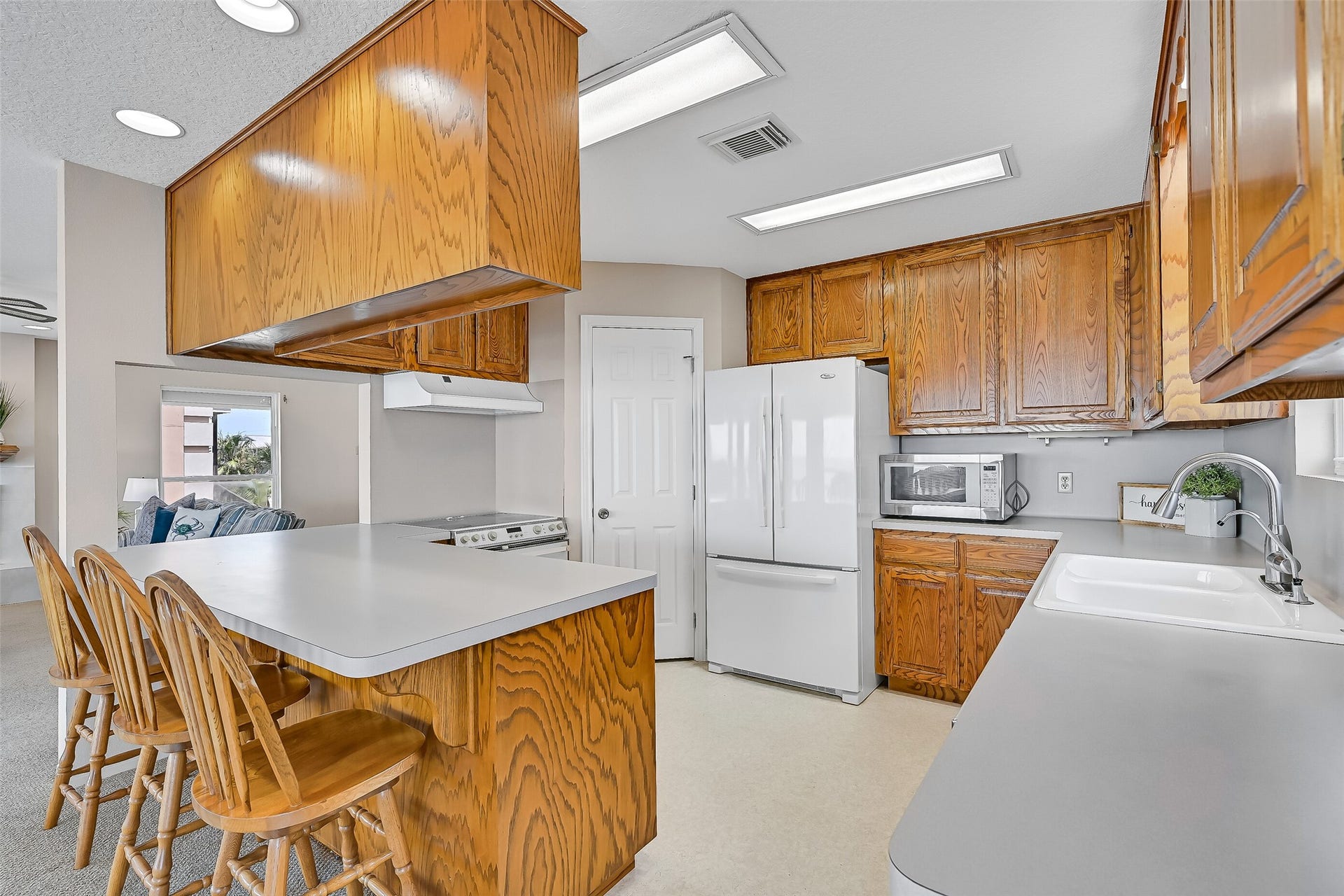 243 Isles End Road, #RR2, Tiki Island, TX 77554 The kitchen offers generous workspace, abundant oak cabinetry, a breakfast bar for casual seating, and a functional layout that opens directly to the living and dining areas. Whether preparing dinner or morning coffee, the bay remains just steps away.