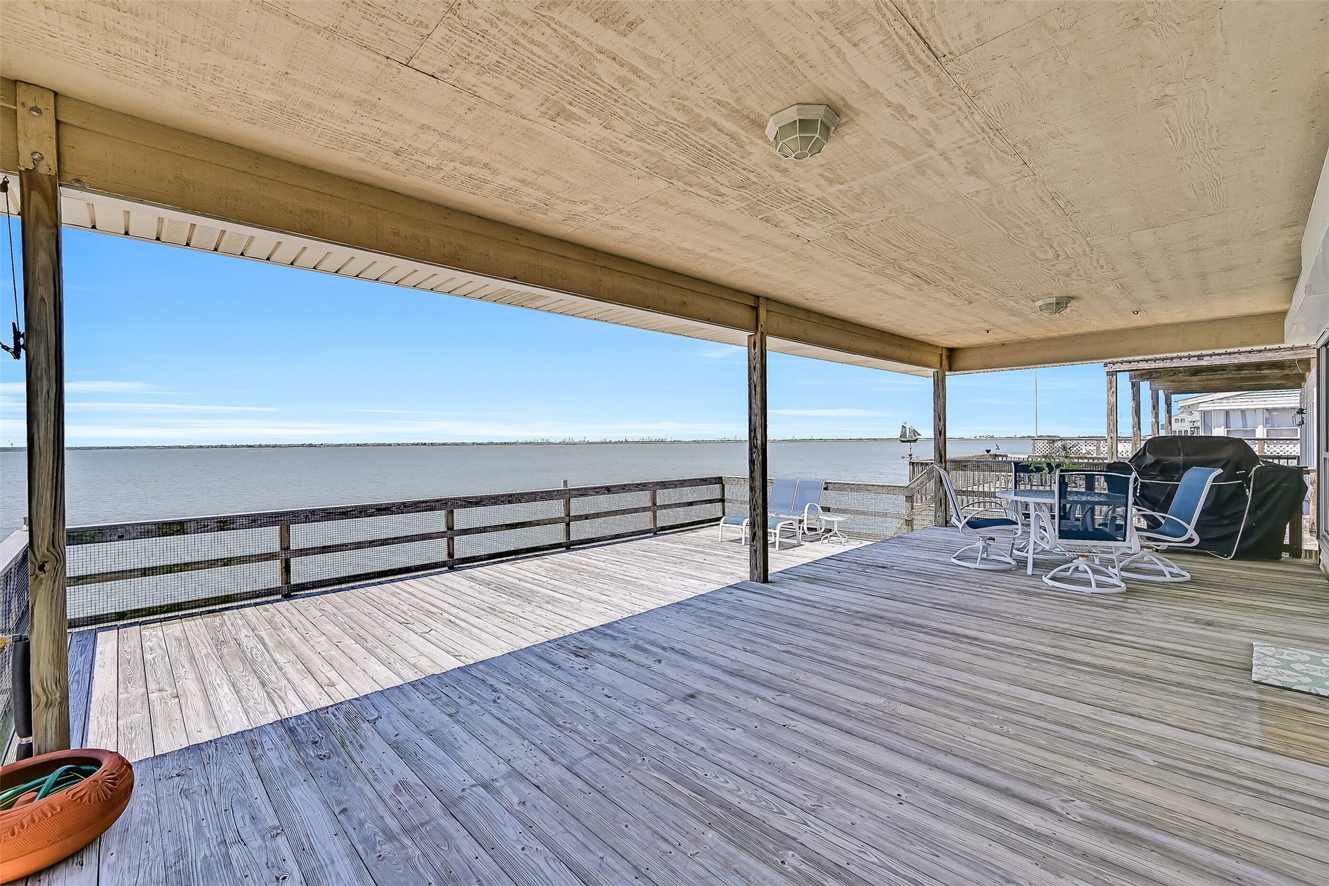 243 Isles End Road, #RR2, Tiki Island, TX 77554 Stretching across the bayside of the home, this oversized deck offers an incredible amount of space for gathering with family and friends while enjoying unobstructed views across Jones Bay toward West Bay. Covered and open-air sections provide options for sun or shade throughout the day, while the west-facing exposure sets the stage for spectacular sunset views year-round.