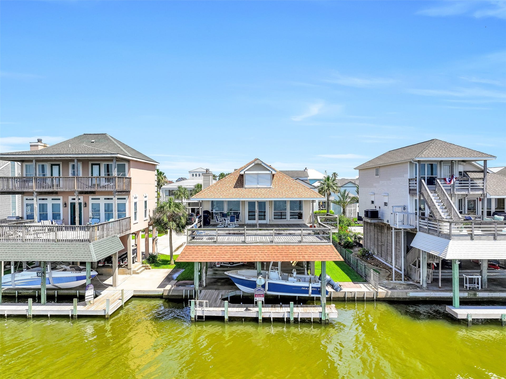 243 Isles End Road, #RR2, Tiki Island, TX 77554 The rear elevation showcases everything that makes coastal living special, including a large entertaining deck, covered boat lift, private dock, and expansive water frontage. Whether you're heading out on the boat or relaxing with friends, the bay is always the centerpiece of the experience.