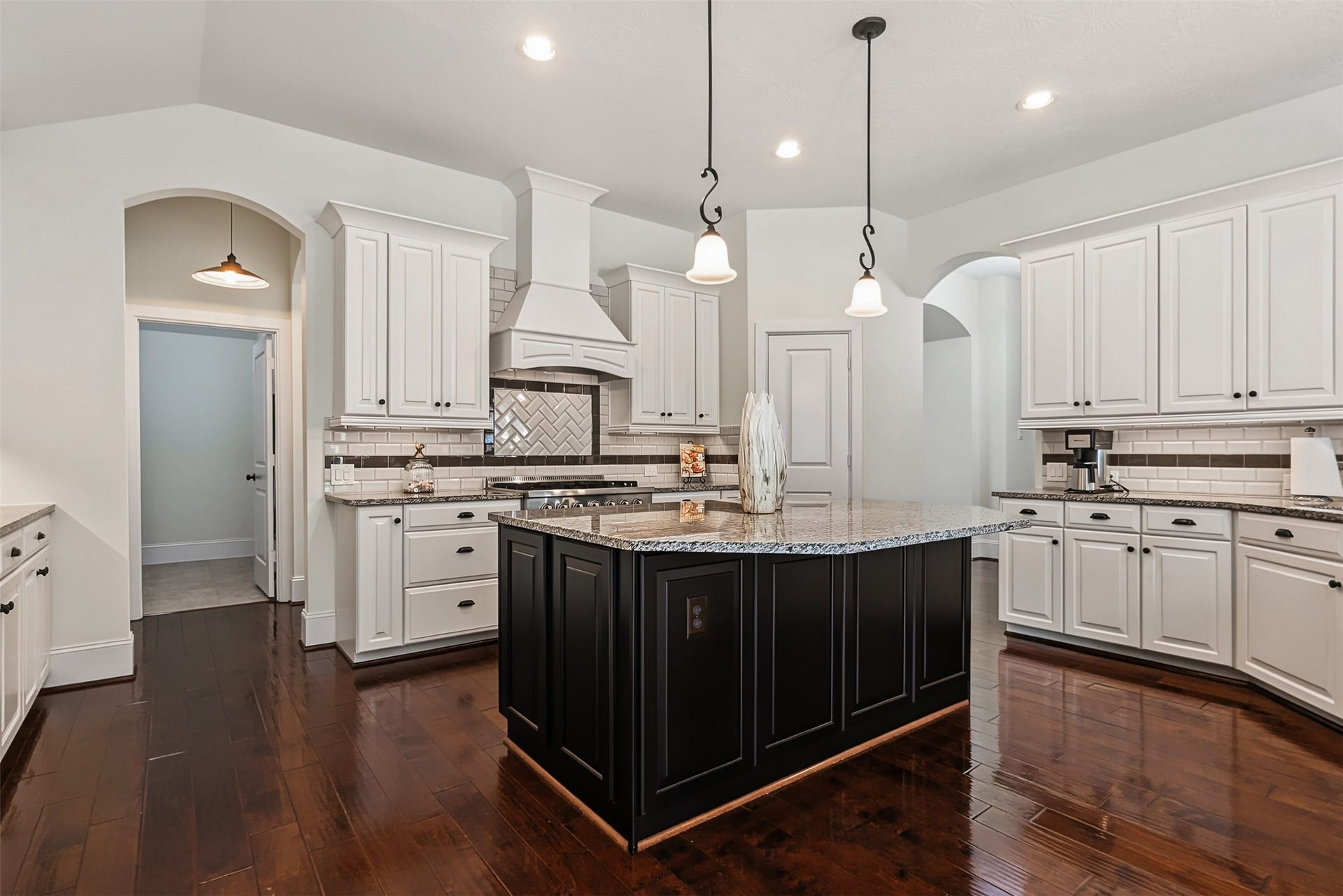 A chef's paradise with a spacious island kitchen, abundant countertop space, pot and pan drawers, and dual pantries.