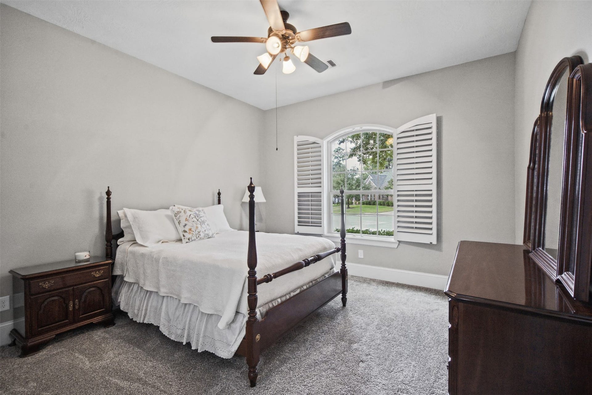 3rd bedroom with walk in closet, plantation shutters and ceiling fan