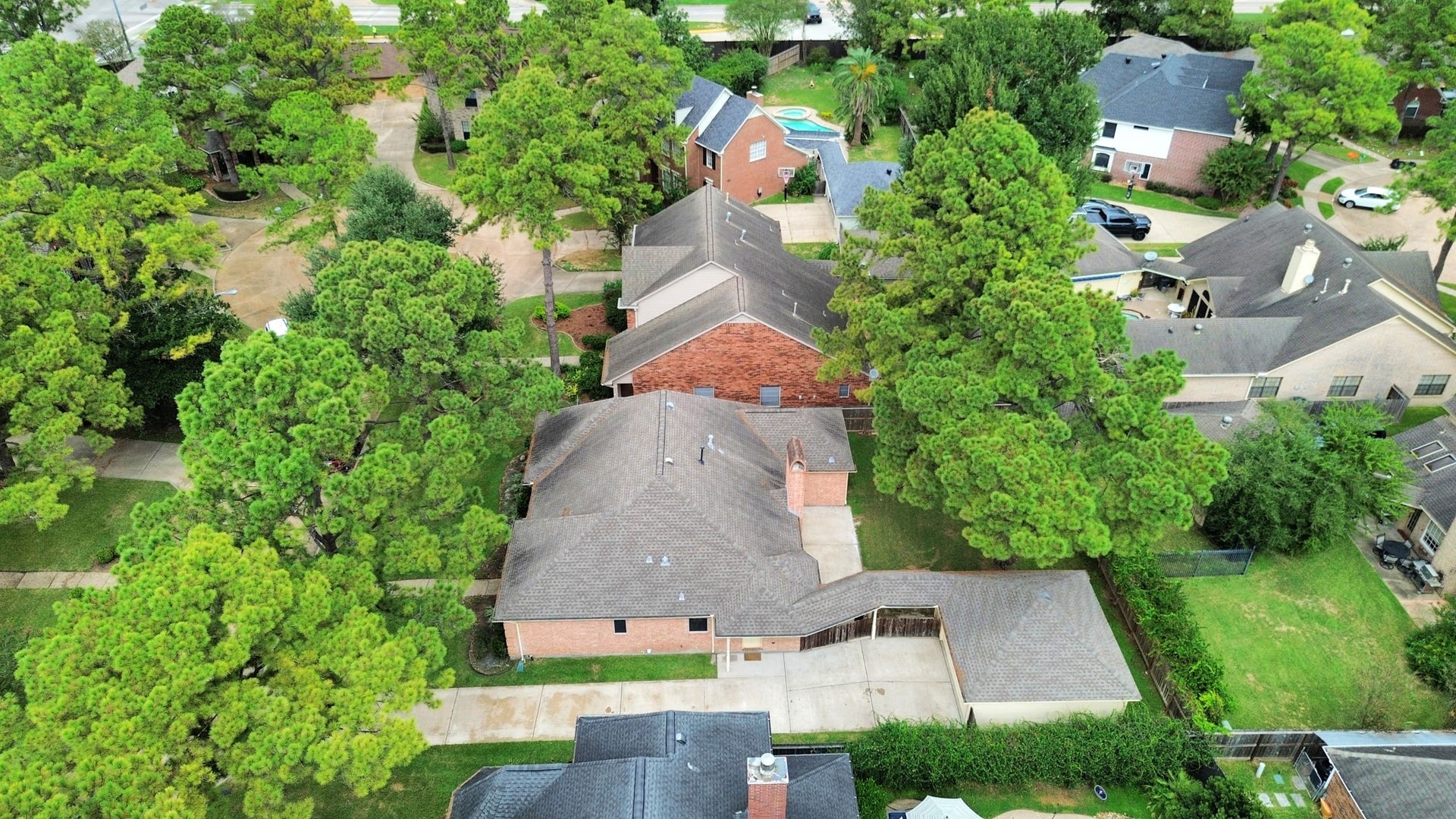 Nestled among lush trees, this charming home boasts a spacious driveway and a well-maintained roof, offering a serene retreat in a picturesque neighborhood.