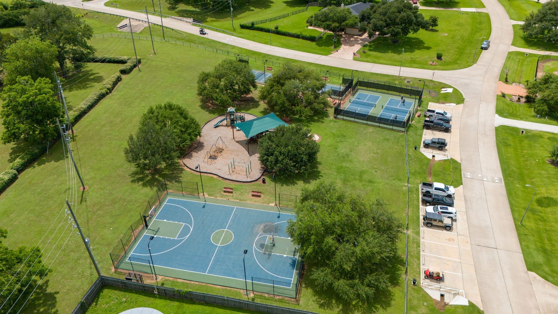 33211 Woodton Court, Weston Lakes, TX 77441 This view showcases another fantastic area of the Weston Lakes community, featuring four pickleball courts, a sport court for basketball, and a playground. With an abundance of recreational amenities throughout the neighborhood, there is always something fun to enjoy for residents of all ages.