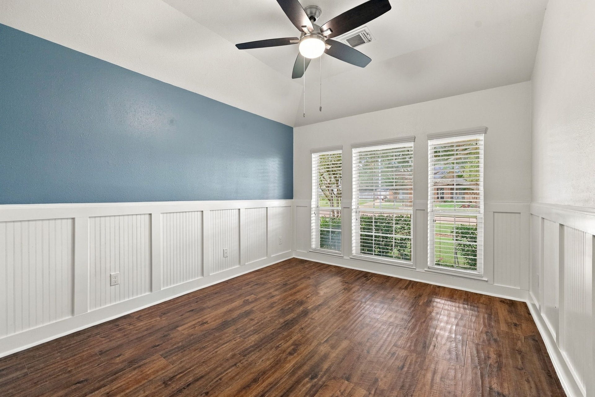 33211 Woodton Court, Weston Lakes, TX 77441 All Secondary Bedrooms are generously sized and feature walk-in closets and gorgeous wood-look tile flooring. This Bedroom located at the front of the home, offers charming details including wainscoting, an accent wall, and a 5-blade ceiling fan. Three windows with 2-inch blinds provide an abundance of natural light and beautiful views of the front yard.
