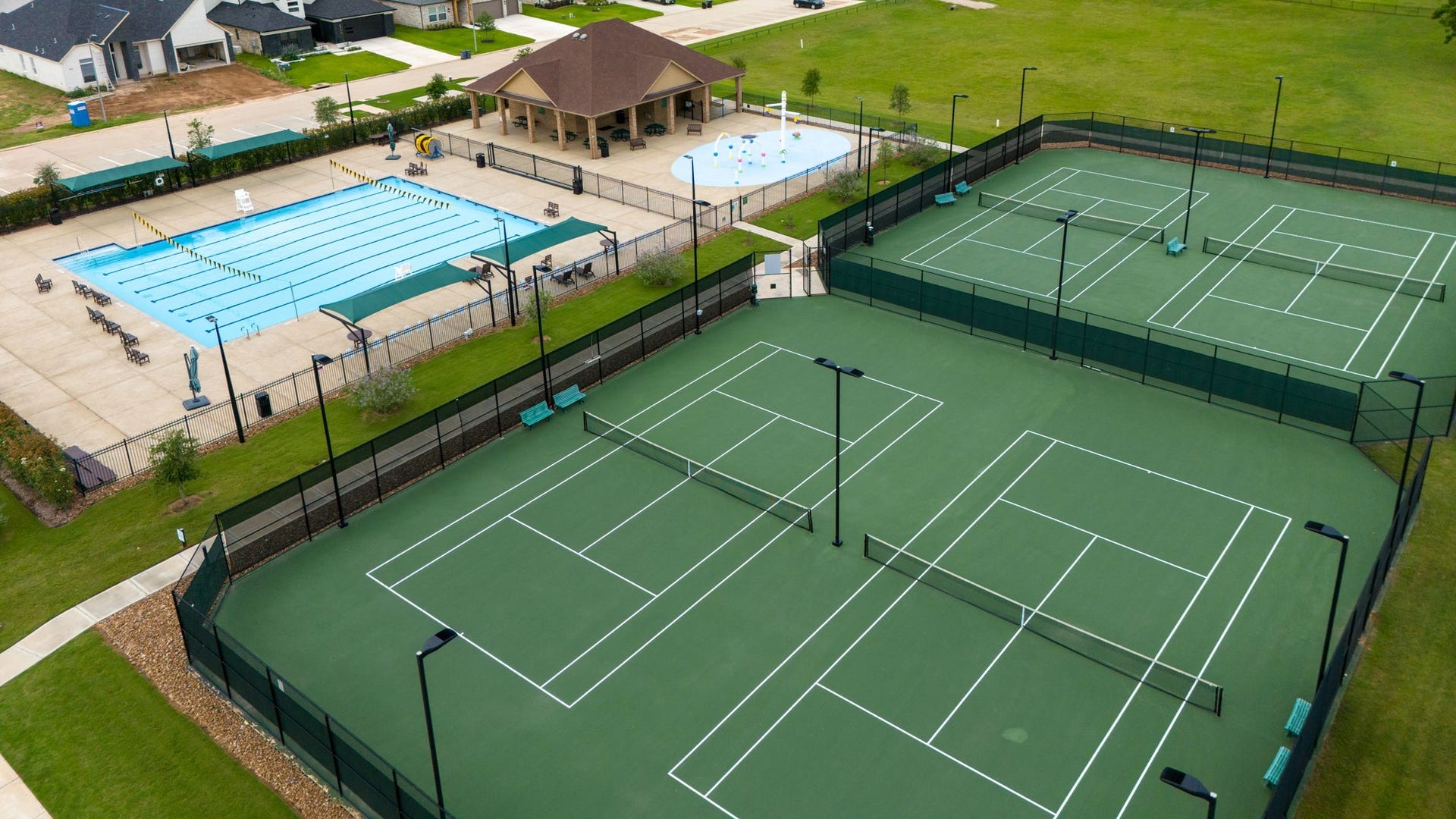 33211 Woodton Court, Weston Lakes, TX 77441 Weston Lakes is a resort-style community offering an abundance of amenities to keep you active and entertained. This photo showcases The Park Recreational Complex featuring 4 tennis courts and one of the communitys two Olympic-size swimming pools, providing residents with exceptional opportunities for recreation, fitness, and relaxation.
