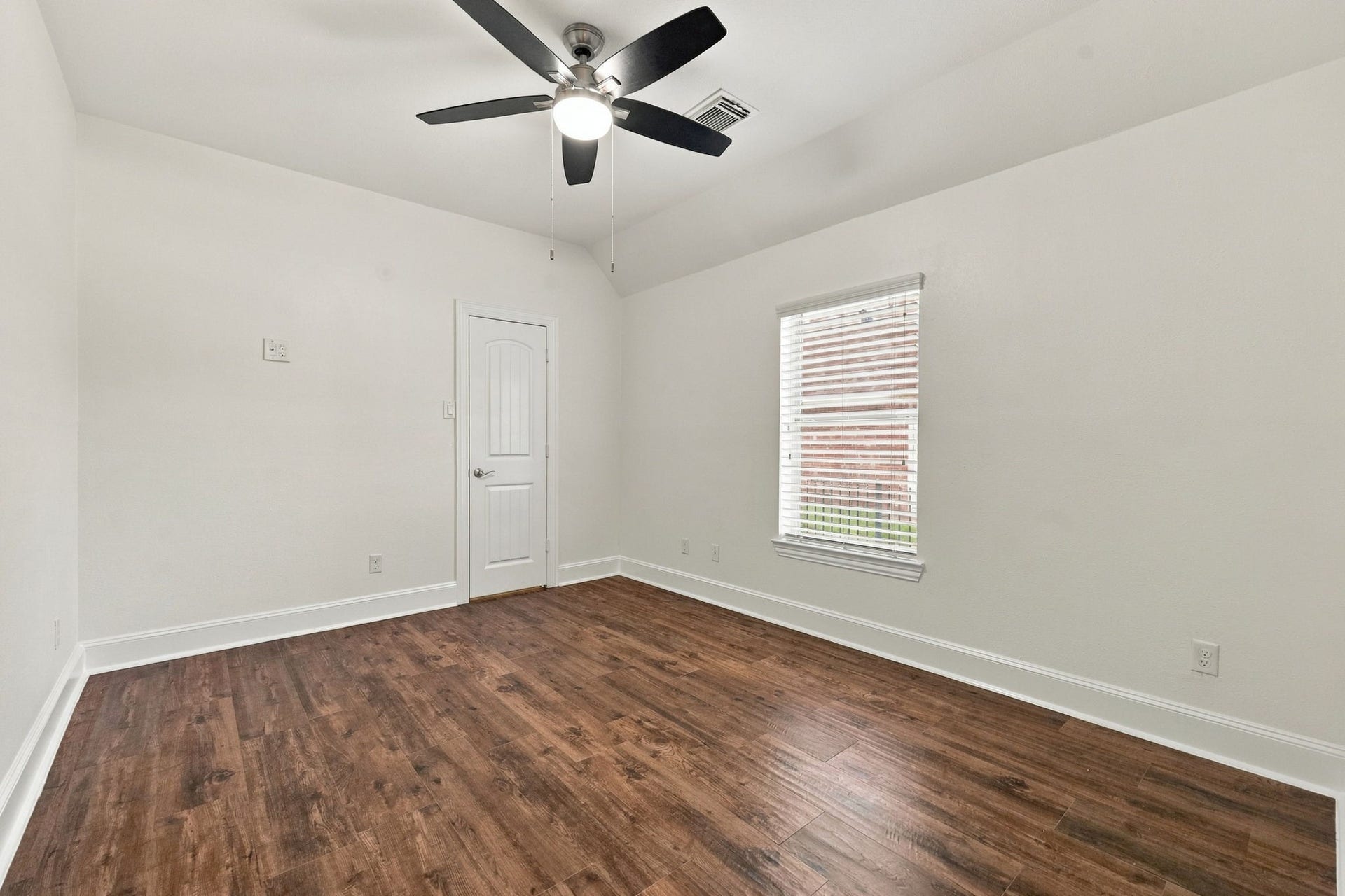33211 Woodton Court, Weston Lakes, TX 77441 This Secondary Bedroom offers beautiful wood-look tile flooring, a convenient mid-wall TV outlet for easy TV installation, a spacious walk-in closet, a window with 2-inch blinds that provides natural light, and a 5-blade ceiling fan for added comfort.