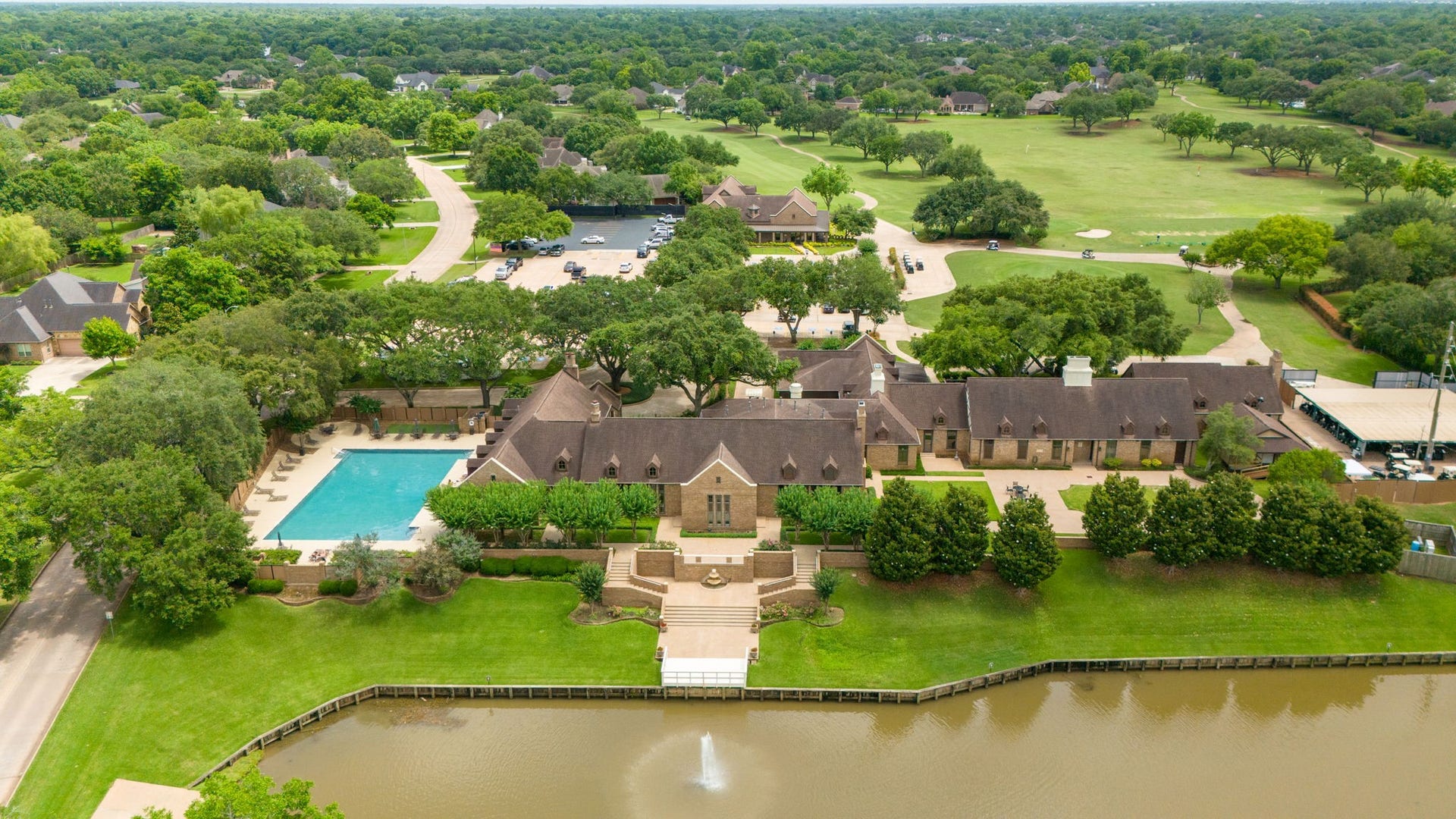 33211 Woodton Court, Weston Lakes, TX 77441 This view showcases the beautiful Weston Lakes Country Club and Waterside Grill, with the golf pro shop and scenic 18-hole golf course visible in the distance. The golf course meanders throughout the community, offering a beautiful setting for enjoying a round of golf. Residents can enjoy golf for an additional fee or upgrade their membership to include golf privileges.