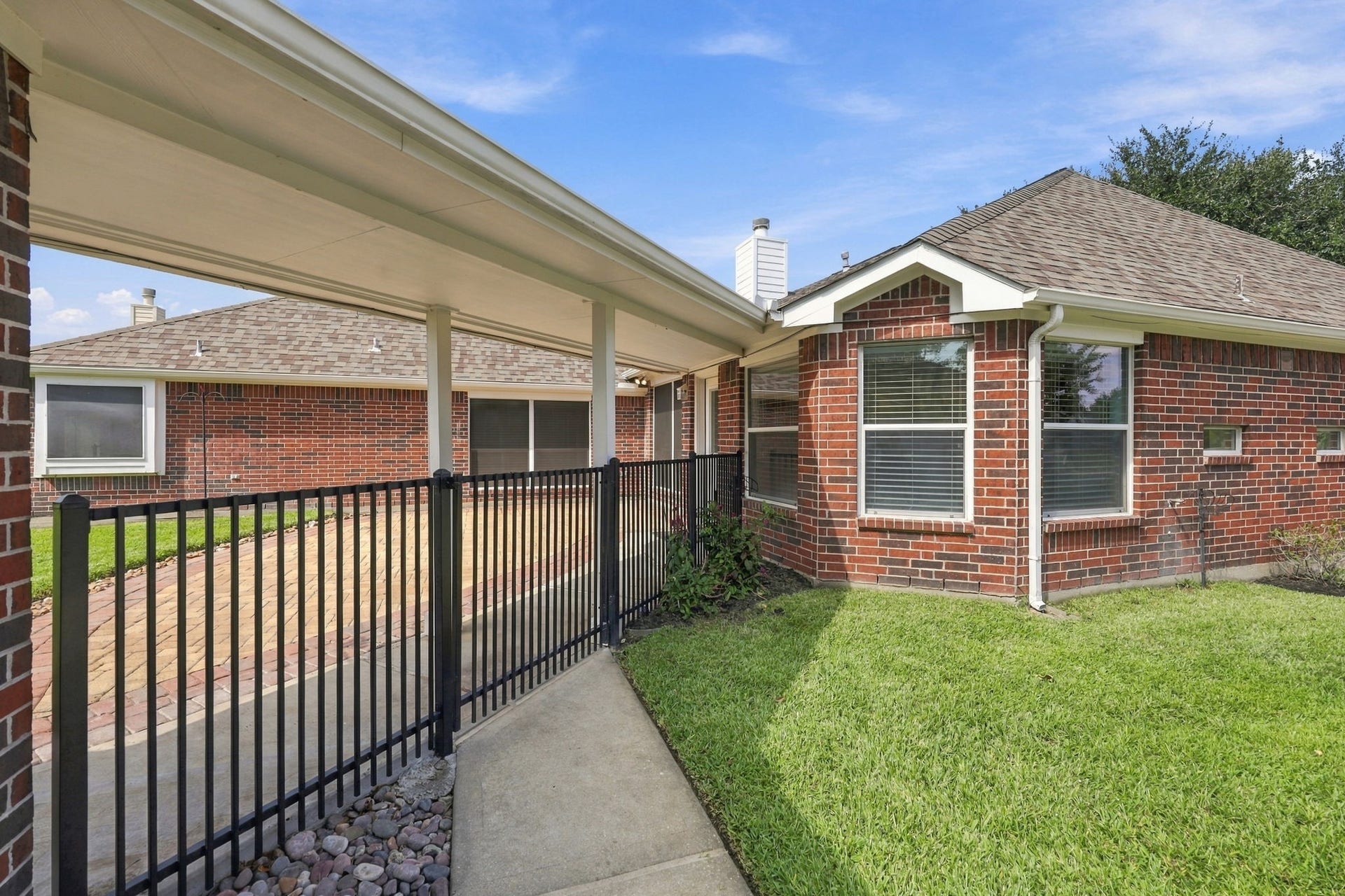 33211 Woodton Court, Weston Lakes, TX 77441 A closer look at the wrought-iron gate separating the driveway from the Backyard, providing an attractive touch while helping create a defined and private outdoor space.