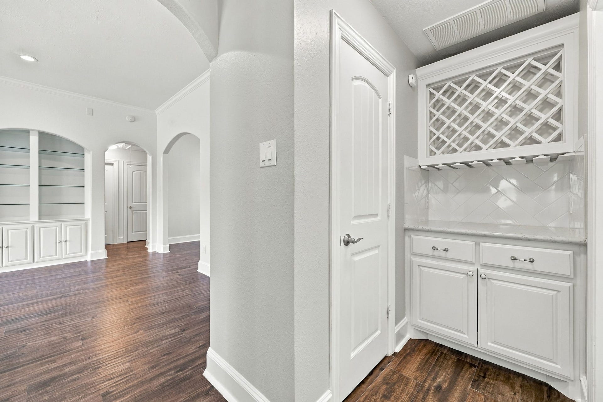 33211 Woodton Court, Weston Lakes, TX 77441 The Butlers Pantry, or Dry Bar, is beautifully appointed with a wine rack to display your favorite selections, convenient hanging storage for wine glasses, soft-close cabinetry and drawers, and additional pantry storage to the left. This thoughtfully designed space is perfect for entertaining while keeping the kitchen organized and clutter-free.