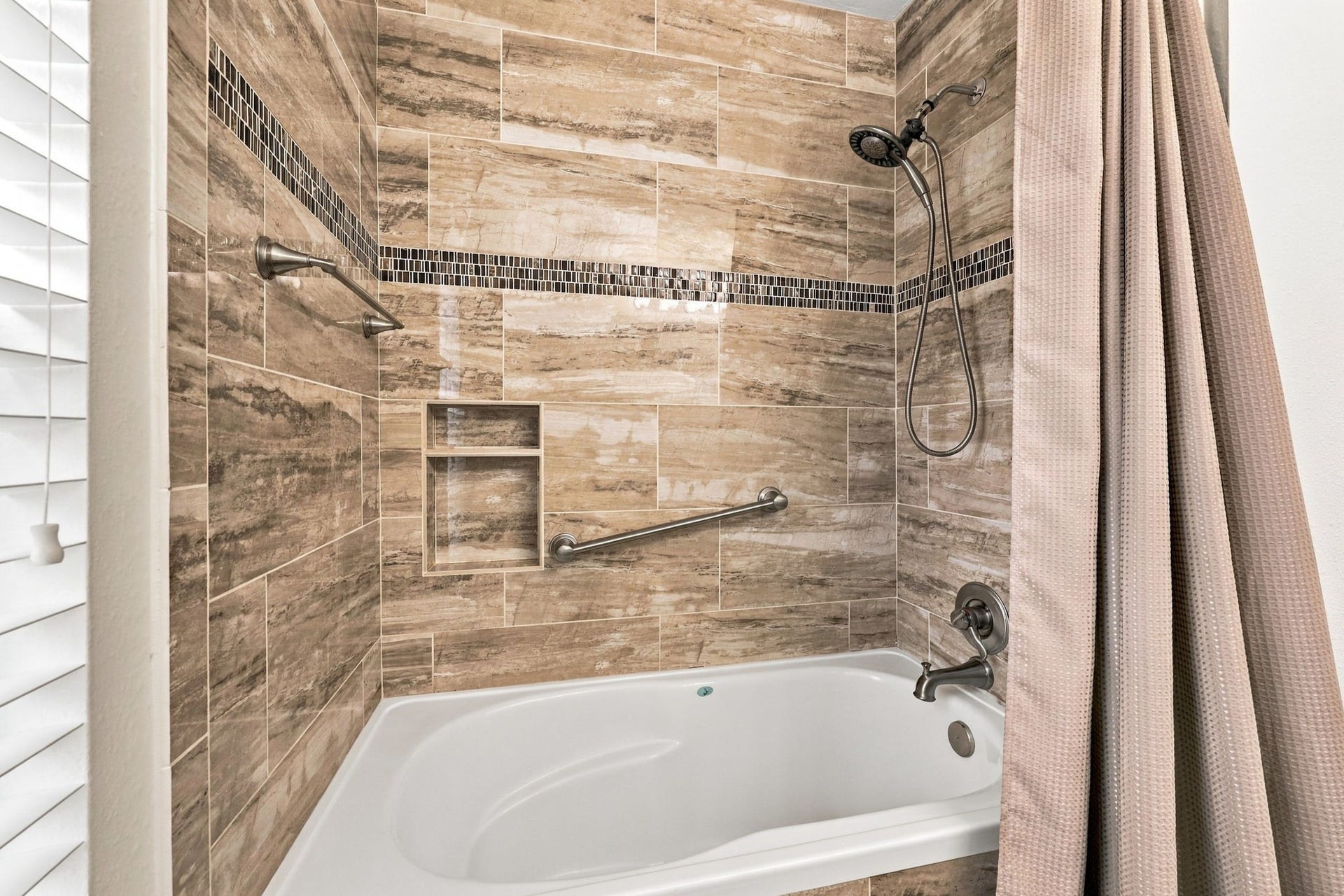 33211 Woodton Court, Weston Lakes, TX 77441 This Full Bath also features a tub/shower combination with designer 12x24 tiled walls accented by a decorative accent strip, complemented by brushed nickel fixtures, including a shower wand and faucet.