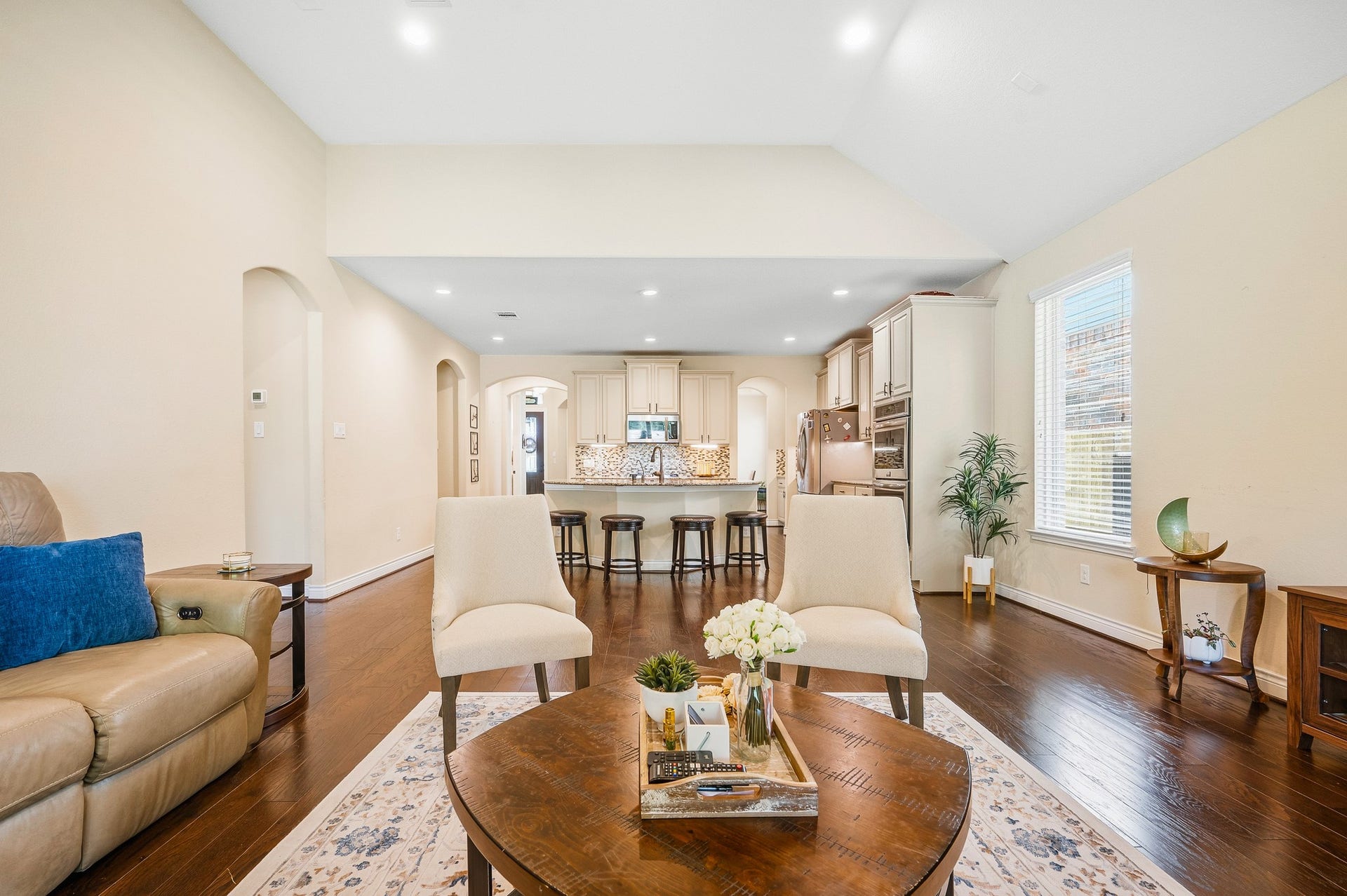 25610 Buckley Bluff Lane, Katy, TX 77494 Experience the perfect blend of elegance and functionality in this spacious open-concept living area, featuring hardwood floors, a cozy seating arrangement, and a modern kitchen with a large island and ample cabinetry, ideal for entertaining and everyday living.