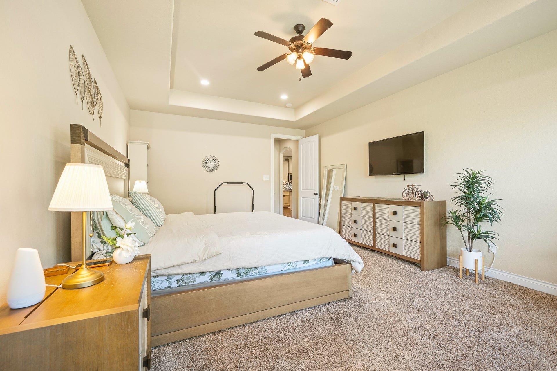 25610 Buckley Bluff Lane, Katy, TX 77494 A spacious bedroom with plush carpeting and abundant natural light, featuring a comfortable bed, elegant ceiling fan, modern dresser, and mounted TV for an inviting retreat.