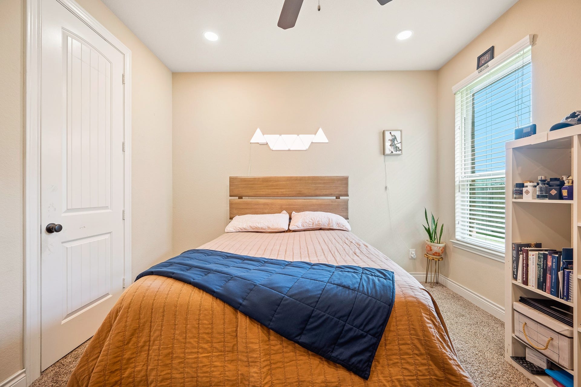 25610 Buckley Bluff Lane, Katy, TX 77494 A cozy bedroom exuding comfort and style, featuring a chic wooden headboard, soft lighting, and a window that bathes the space in inviting natural light.