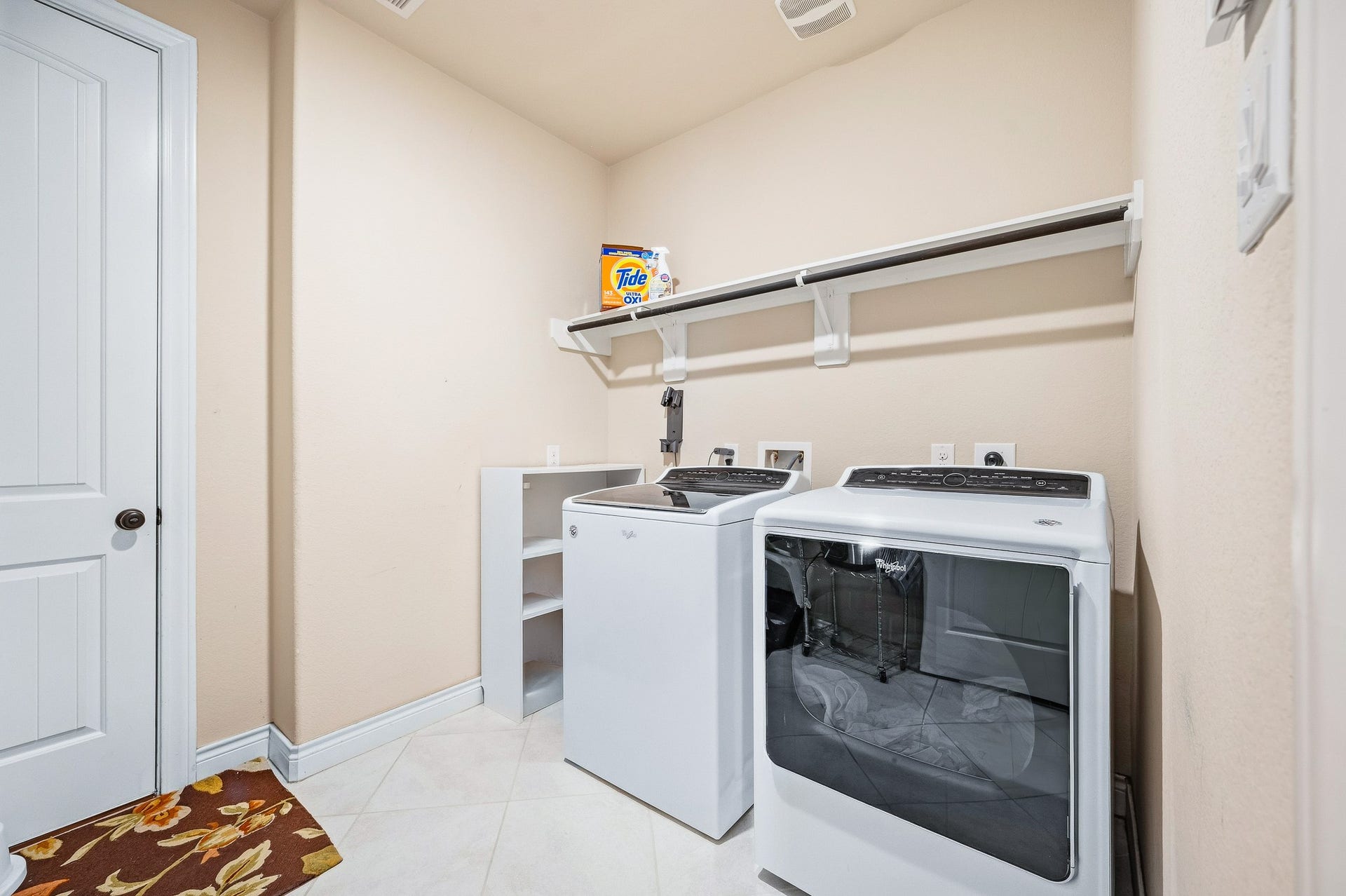 25610 Buckley Bluff Lane, Katy, TX 77494 Discover a modern laundry room featuring a sleek washer and dryer set, abundant shelving for organized storage, and easy-to-maintain neutral tile flooring.