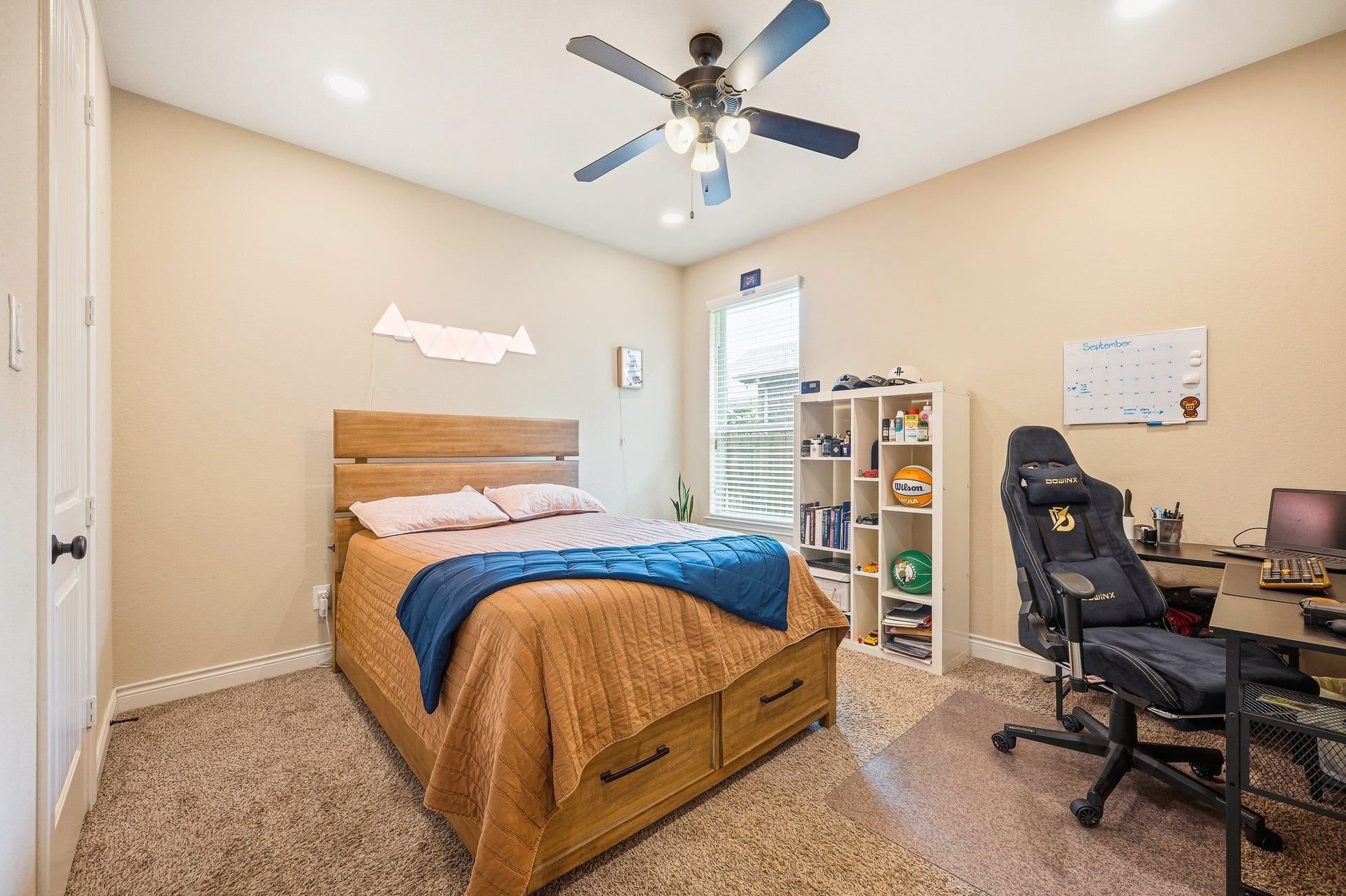 25610 Buckley Bluff Lane, Katy, TX 77494 Cozy bedroom featuring a comfortable bed with under-storage, a ceiling fan, and a well-organized desk area perfect for work or study.