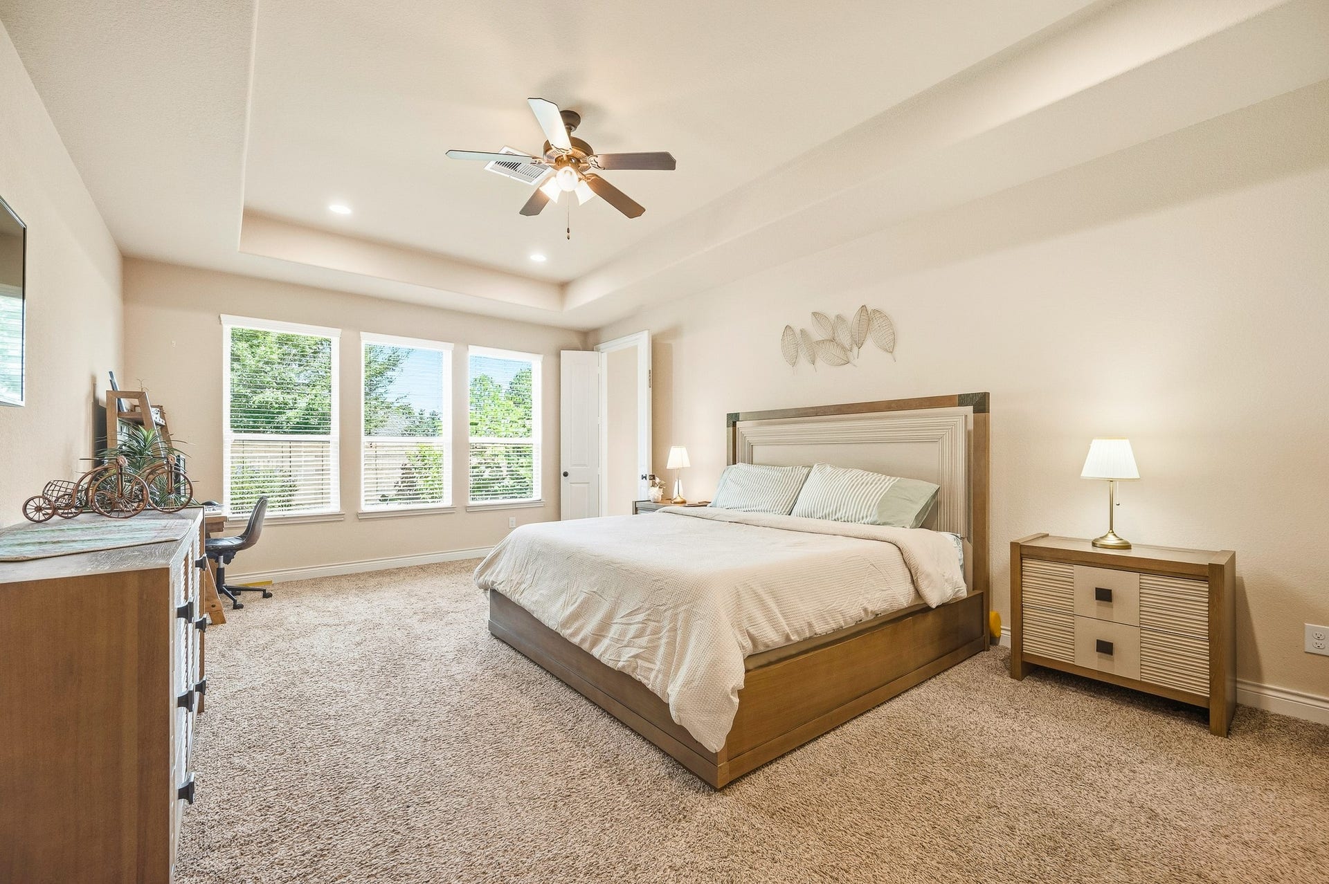 25610 Buckley Bluff Lane, Katy, TX 77494 A spacious and inviting bedroom, illuminated by large windows that flood the room with natural light, is complemented by plush carpeting for a cozy and relaxing atmosphere.